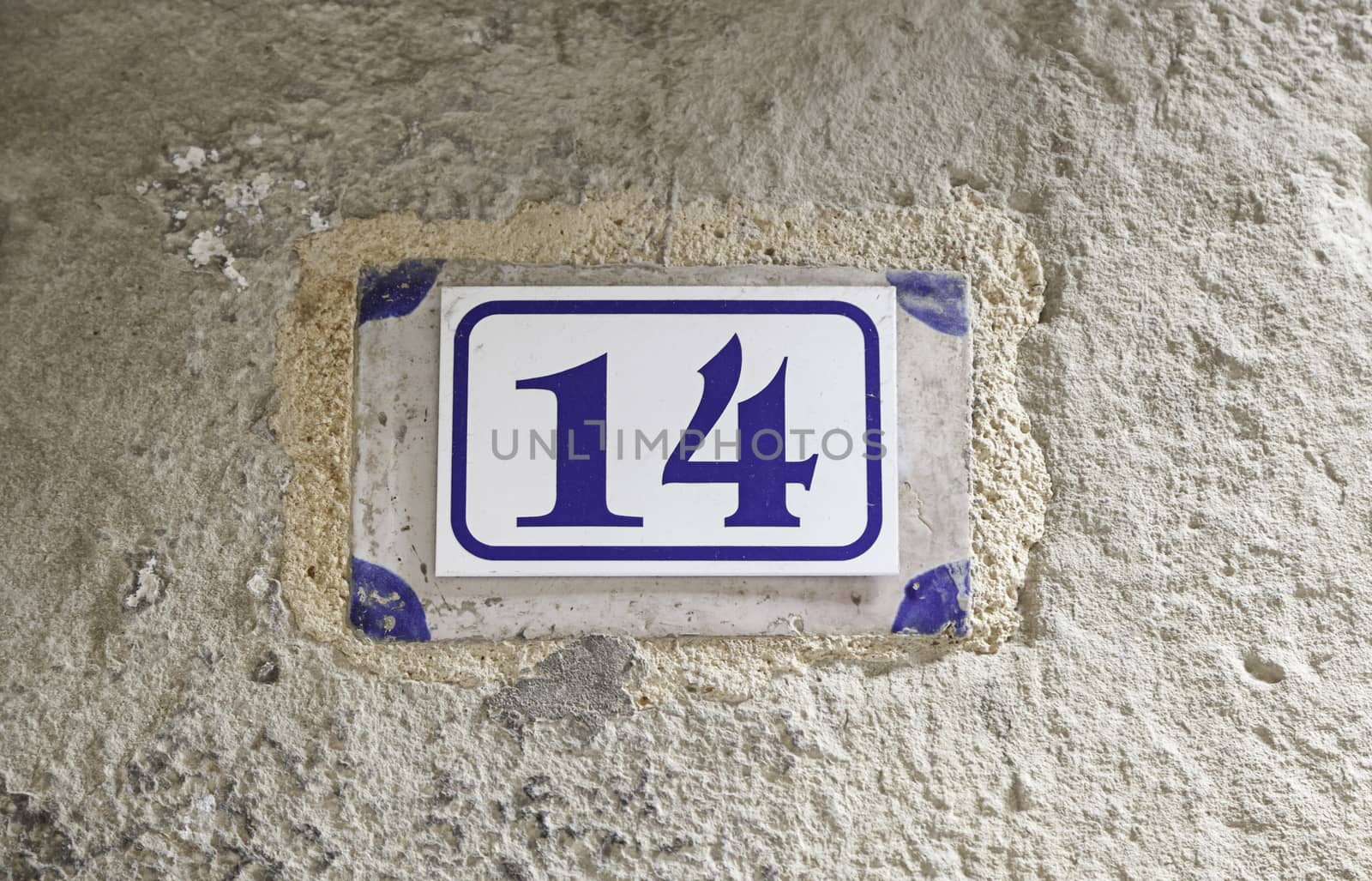 Number fourteen on a wall, detail of a number on the wall of a house, information number, even number