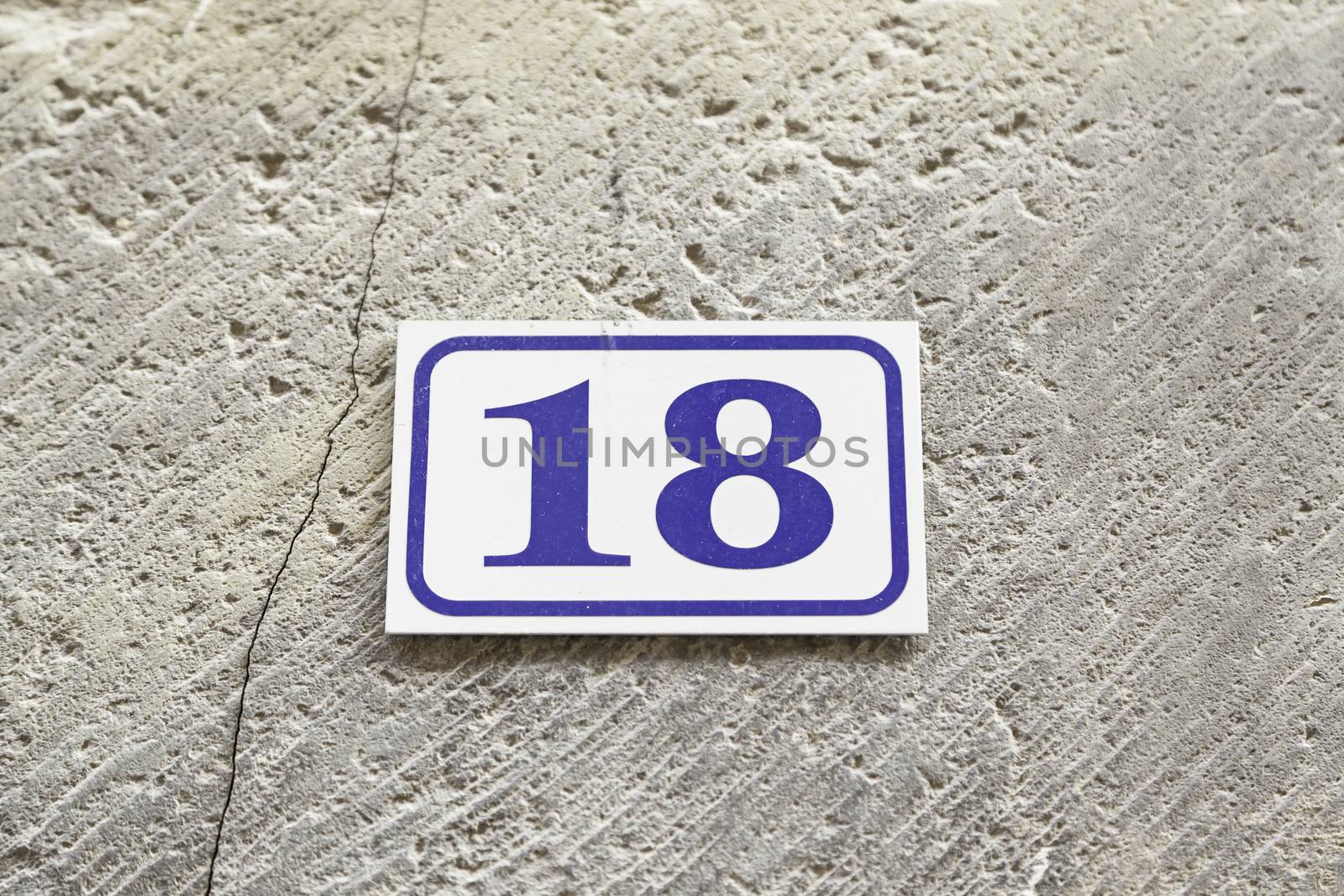 Number eighteen on a wall, detail of a number of information on a wall, even number