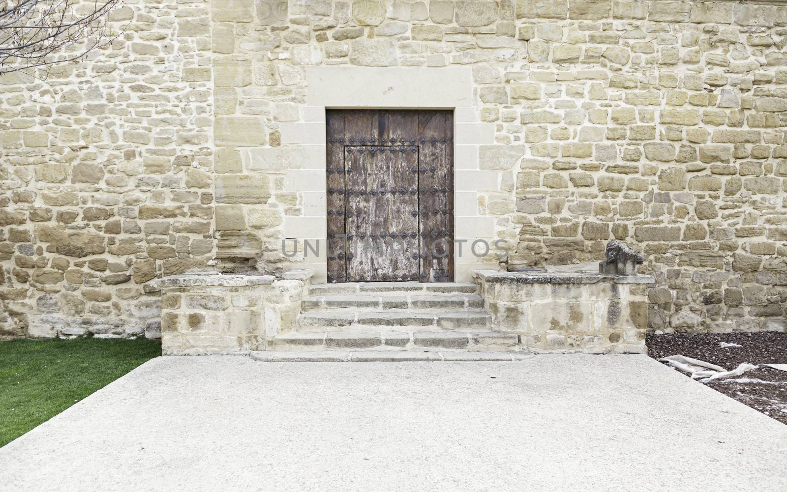 Ancient medieval wooden door, detail of a stone wall with a locked door, protection