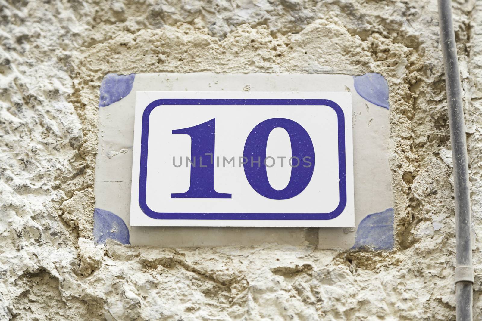 Number ten on a wall, detail of a number of information on a wall of a house, even number