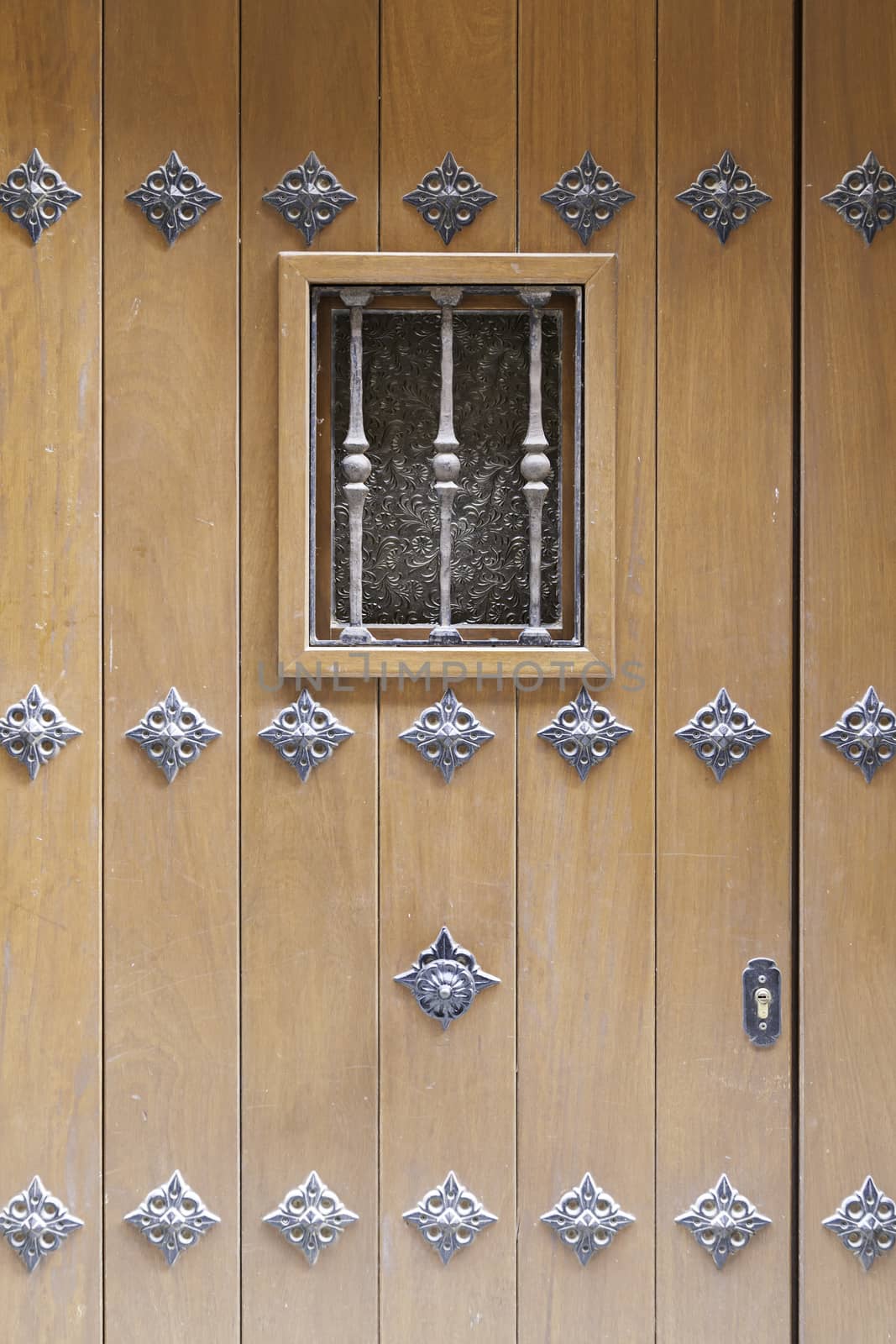 Old wooden door with window detail of a decorated wooden door, protection and decoration