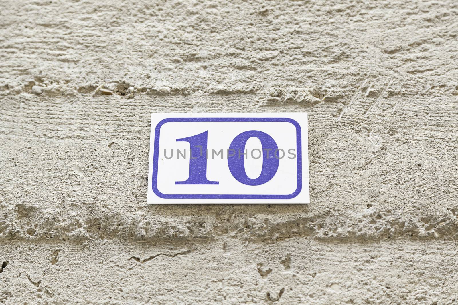 Number ten on a wall, detail of a number of information on a wall of a house, even number