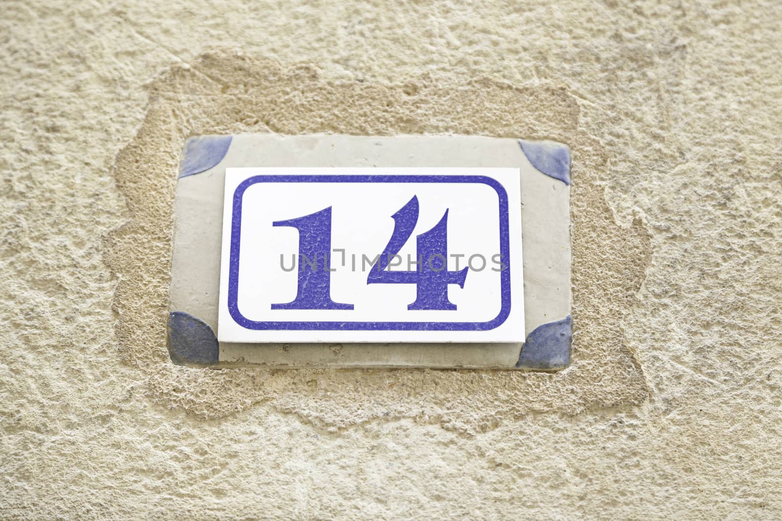 Number fourteen on a wall, detail of a number on the wall of a house, information number, even number