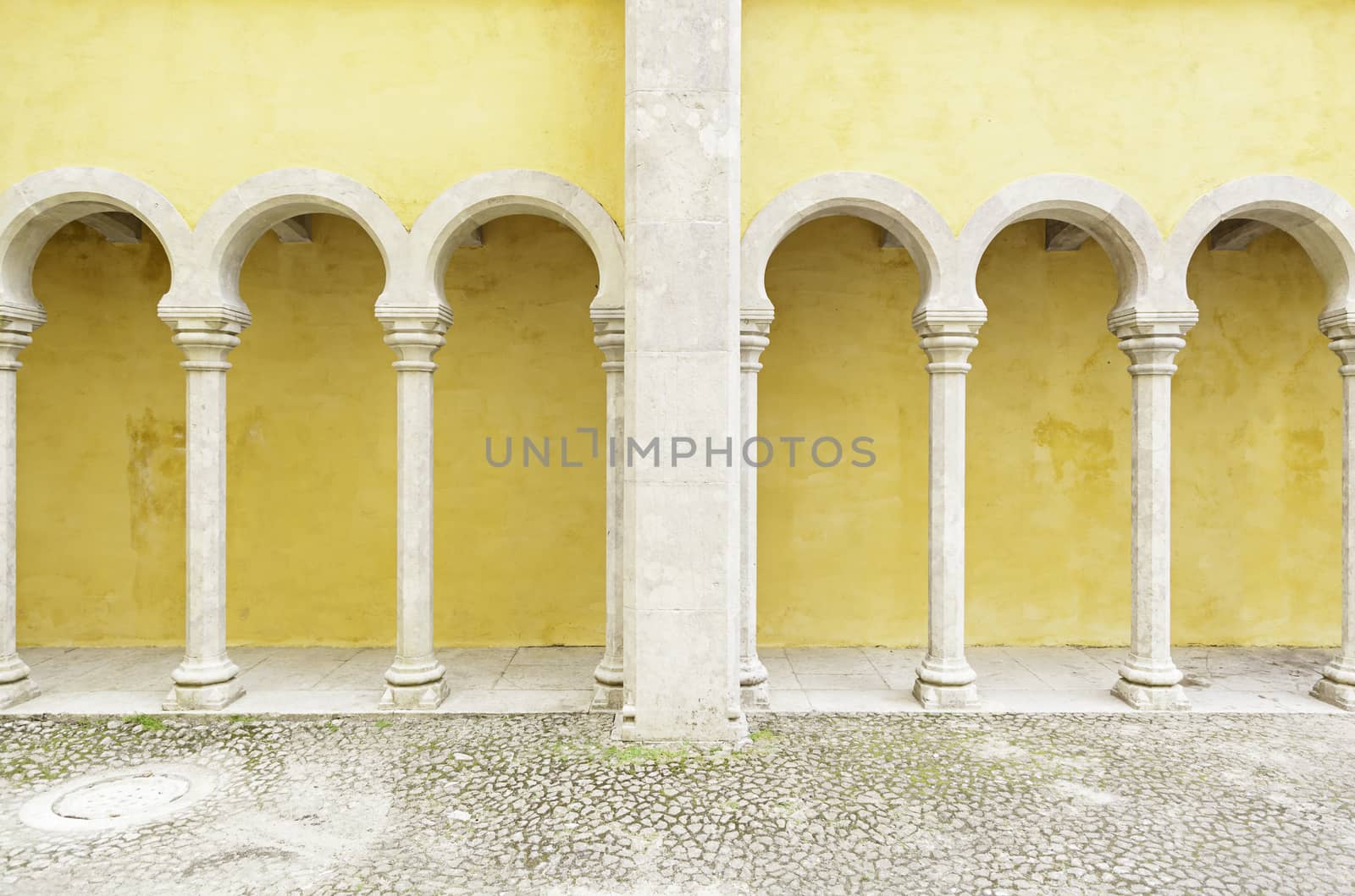 Ancient yellow arches in the Pena Palace, detail of ancient architecture, heritage of humanity, tourism