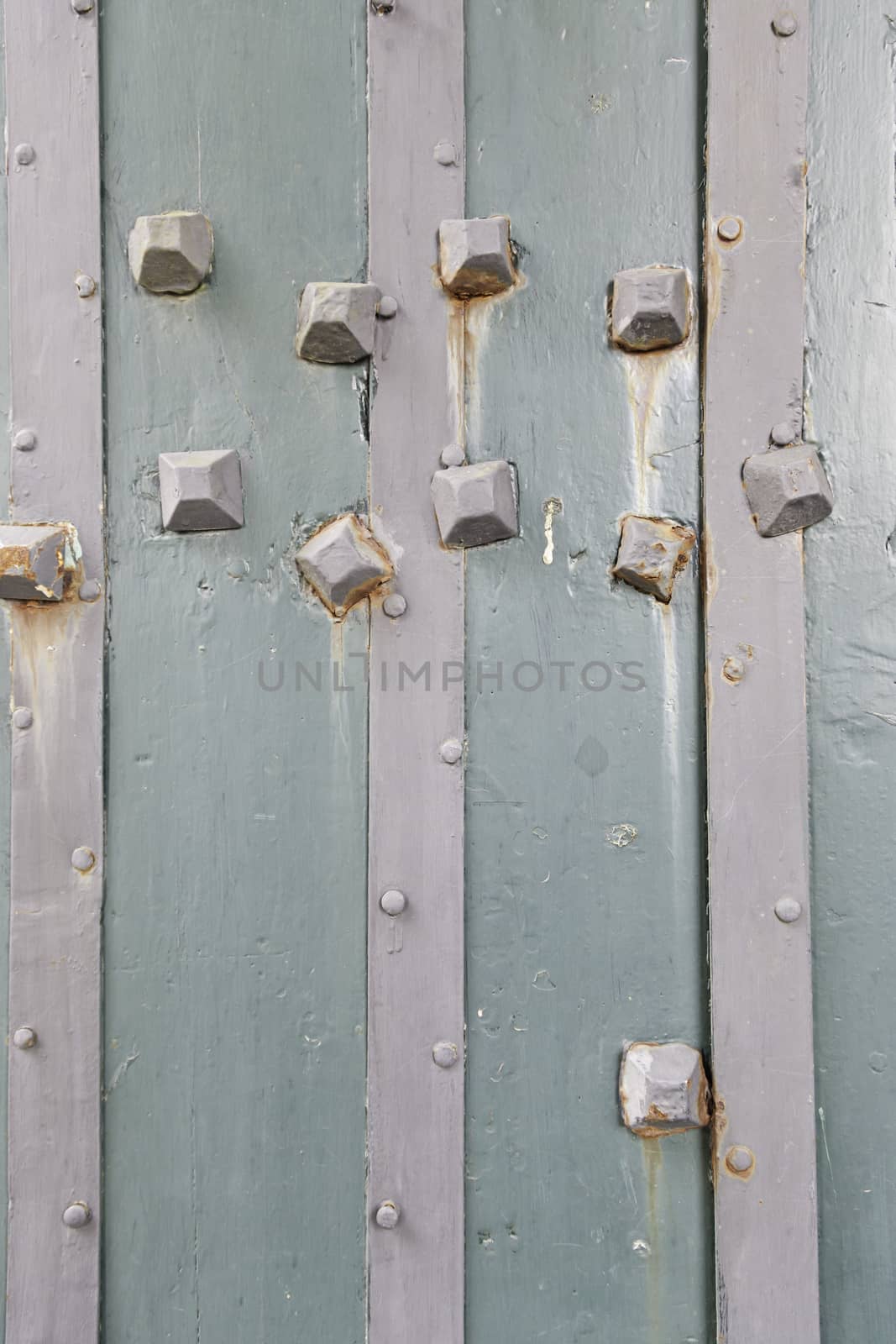 Old wooden door with metal nails, detail of a wooden door shabby textured background