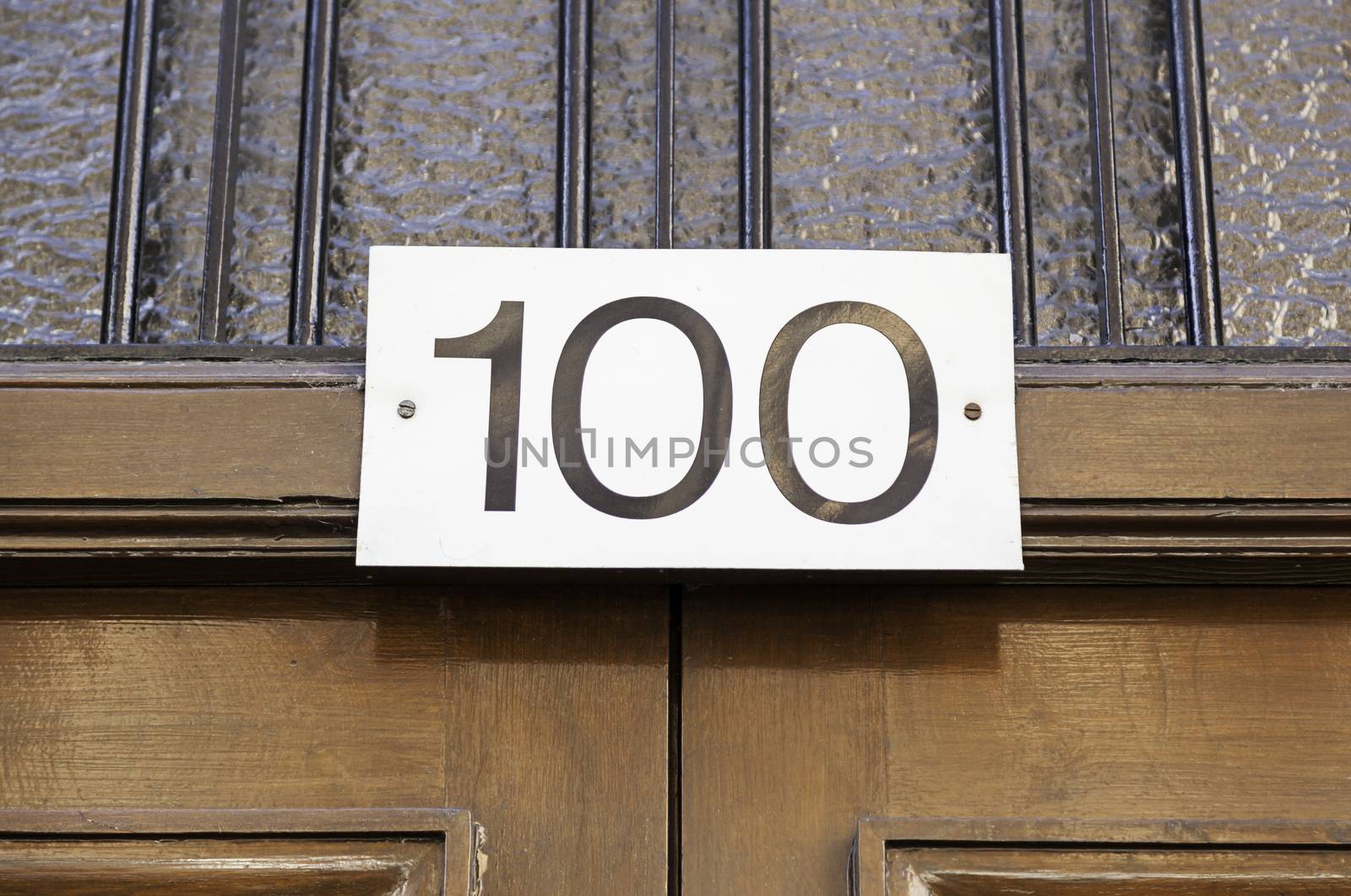 Number one hundred on a wall, detail of a number of information in a house in the city