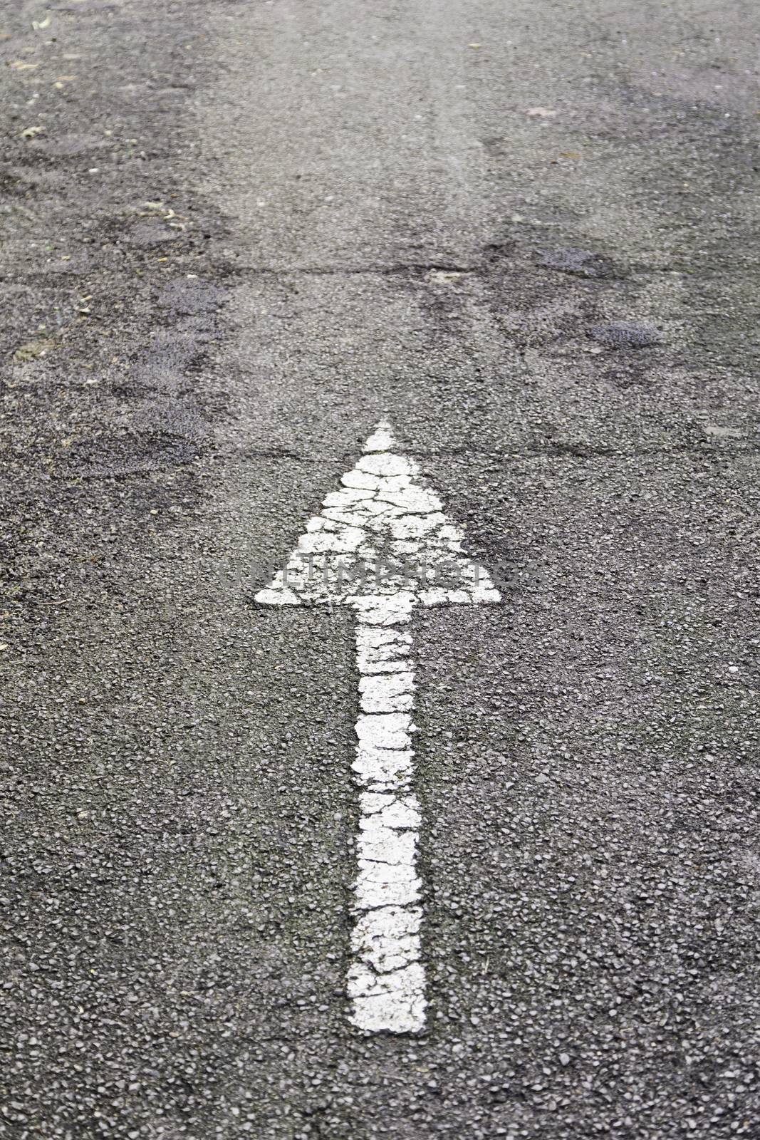 Arrow direction on asphalt, detail of an arrow of indexation on a highway, road information