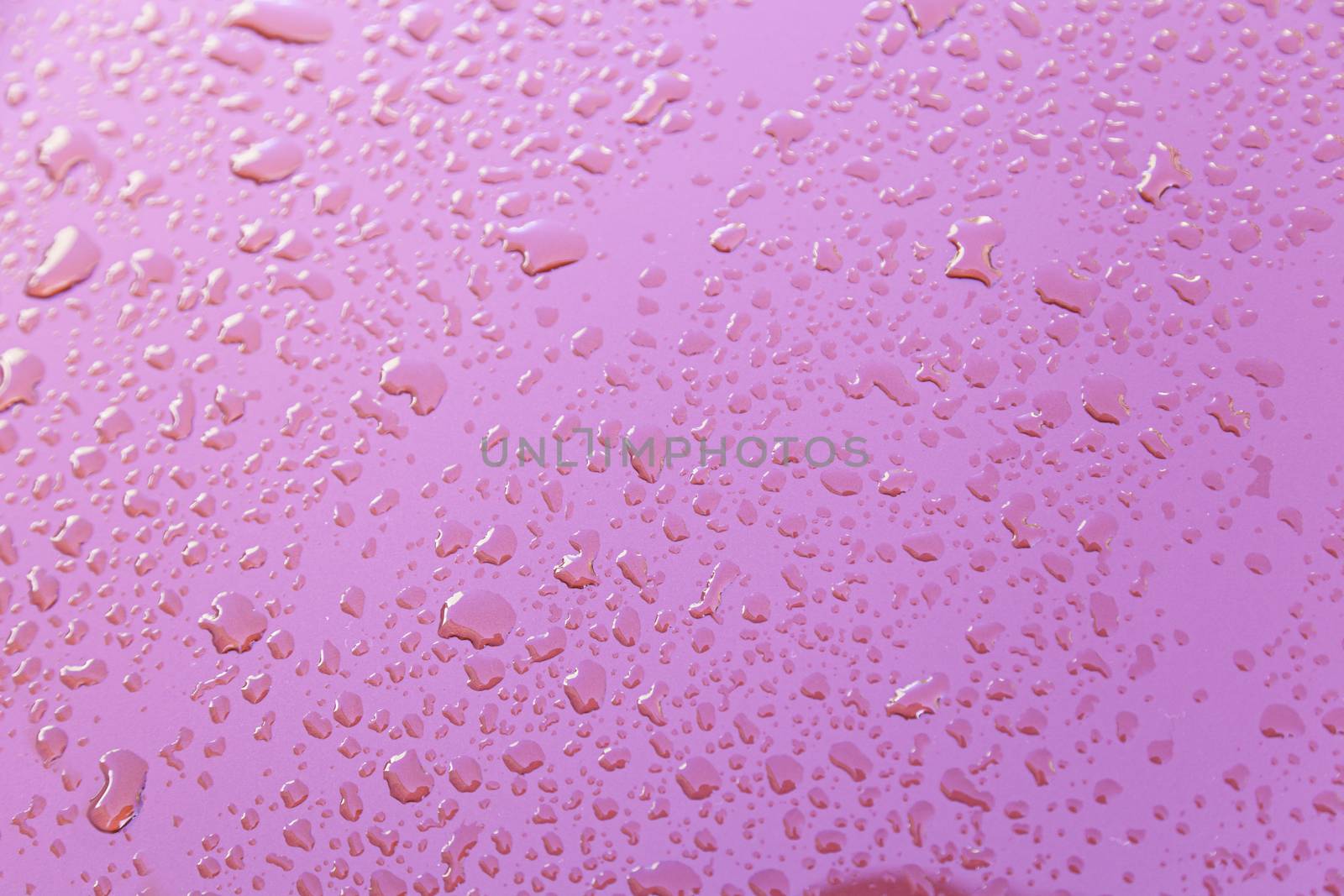 Raindrops on red wall, detail of a red wall wet with water, textured background