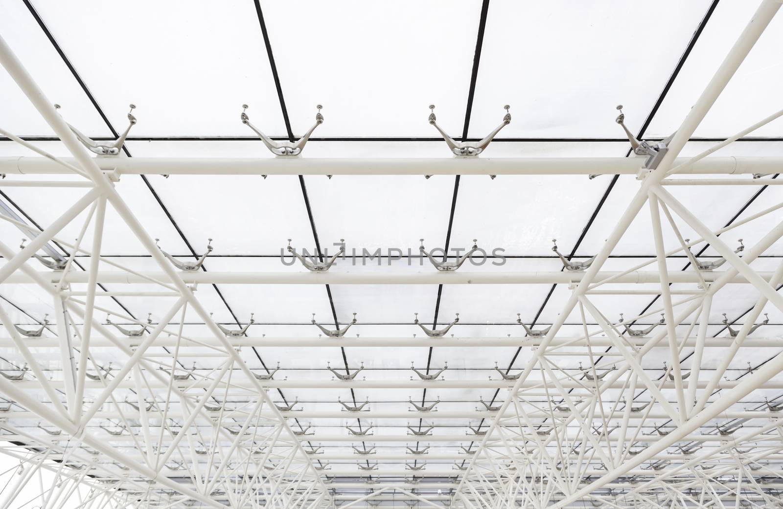 Glass roof with white beams, detail of a roof with sky views, safety and security