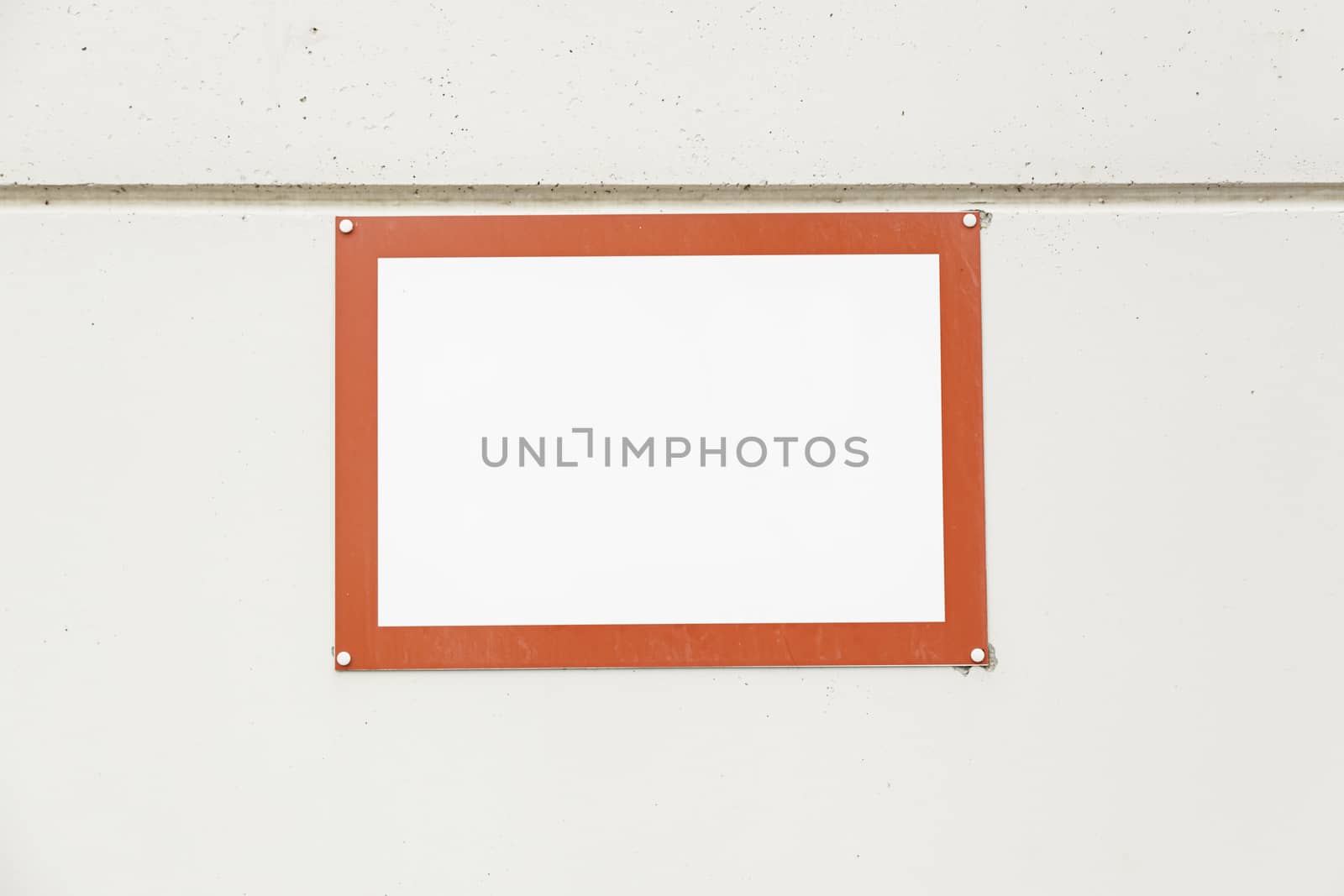 Red frame on a wall, detail of a red frame in a concrete wall, space for text