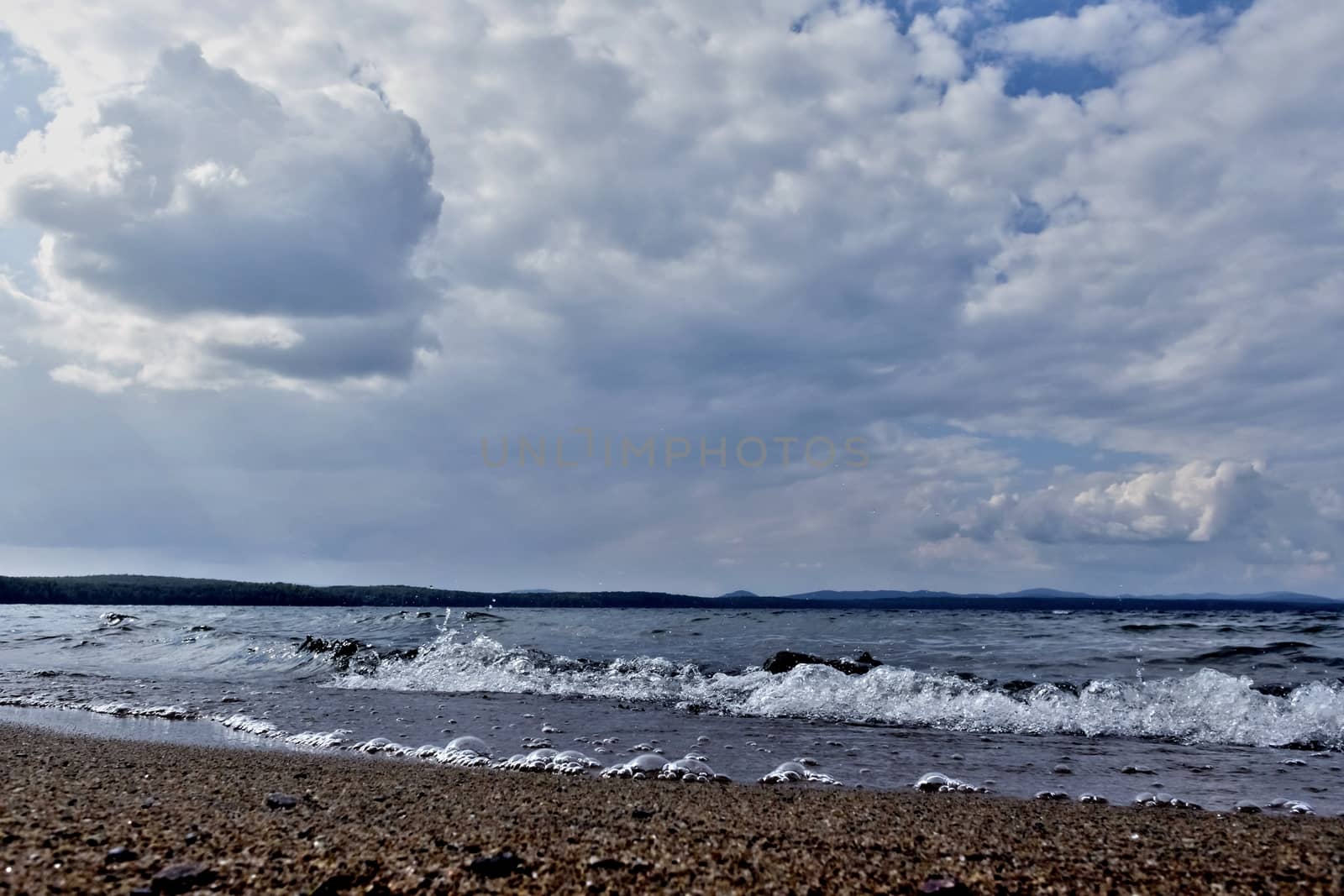 view of the lake with cumulonimbus clouds above it in windy weather, low point shooting