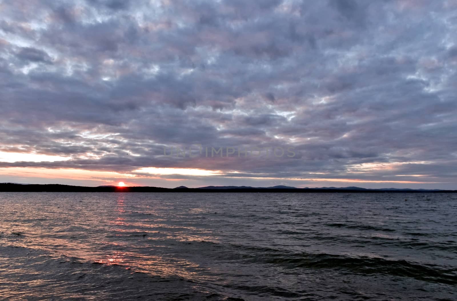 evening lake in cloudy weather, South Ural, Uvildy, in the distance are seen the Ural mountains