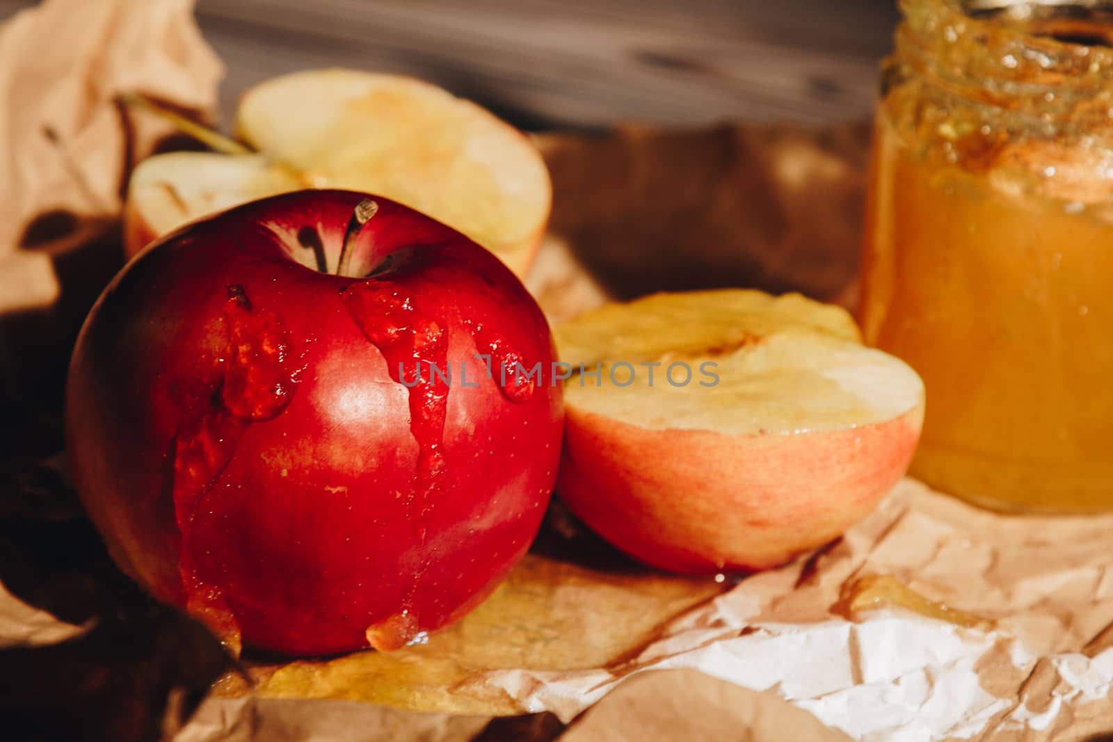 Honey with wooden honey dipper paper napkin and fruits on wooden table close up by yulaphotographer