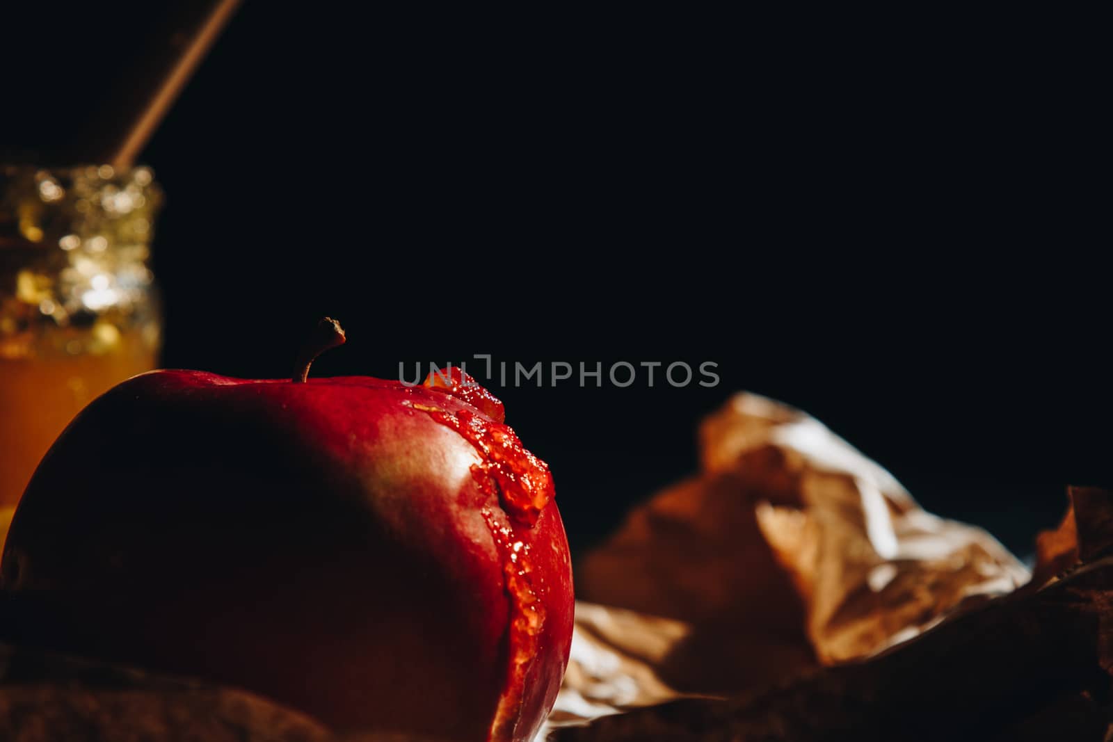 Honey with wooden honey dipper paper napkin and fruits on wooden table close up by yulaphotographer