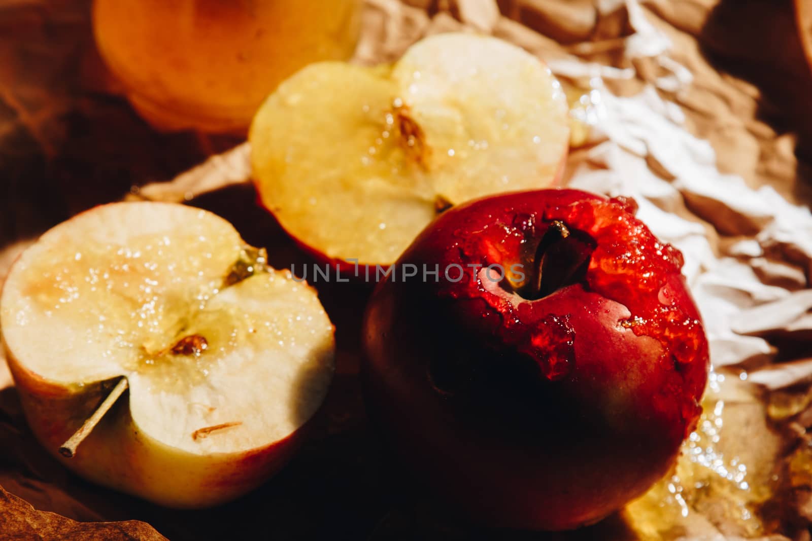 Honey with wooden honey dipper paper napkin and fruits on wooden table close up by yulaphotographer