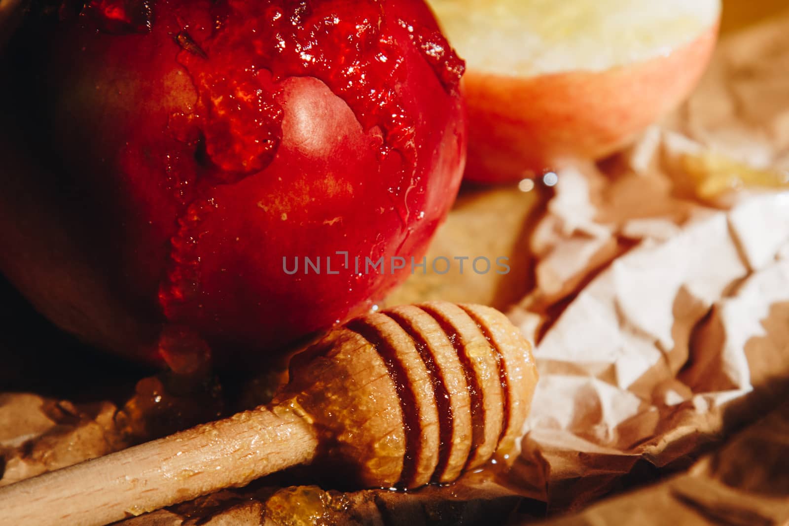 Honey with wooden honey dipper paper napkin and fruits on wooden table close up by yulaphotographer