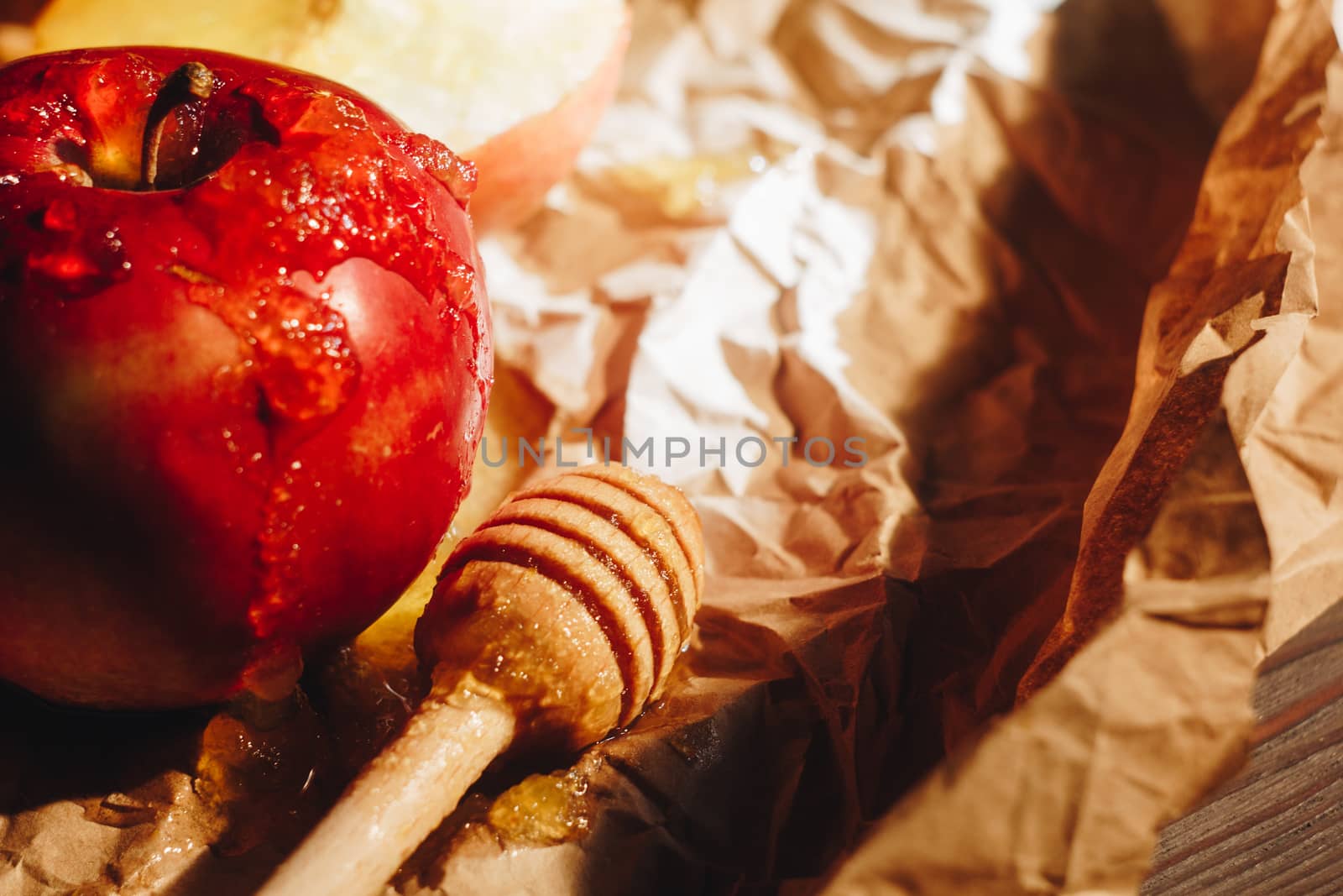 Honey with wooden honey dipper paper napkin and fruits on wooden table close up by yulaphotographer