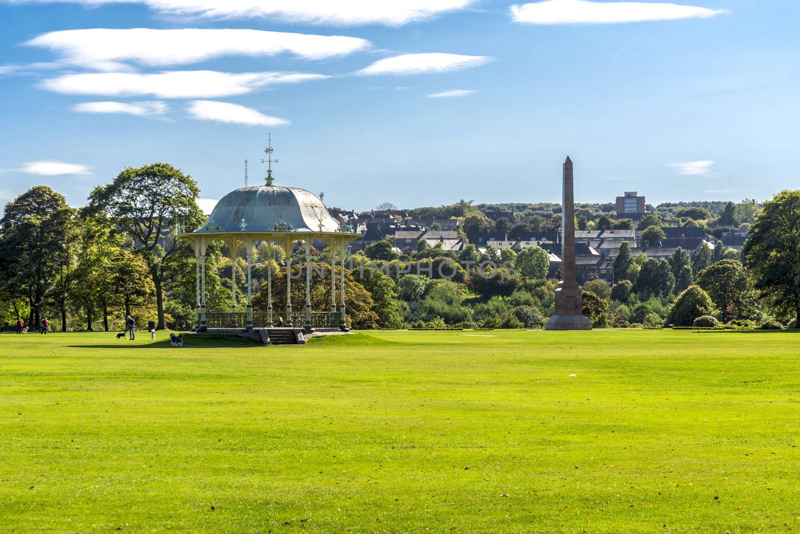 A large lawn with a scenic arbour and McGrigor obelisk in Duthie park, Aberdeen, Scotland by anastasstyles