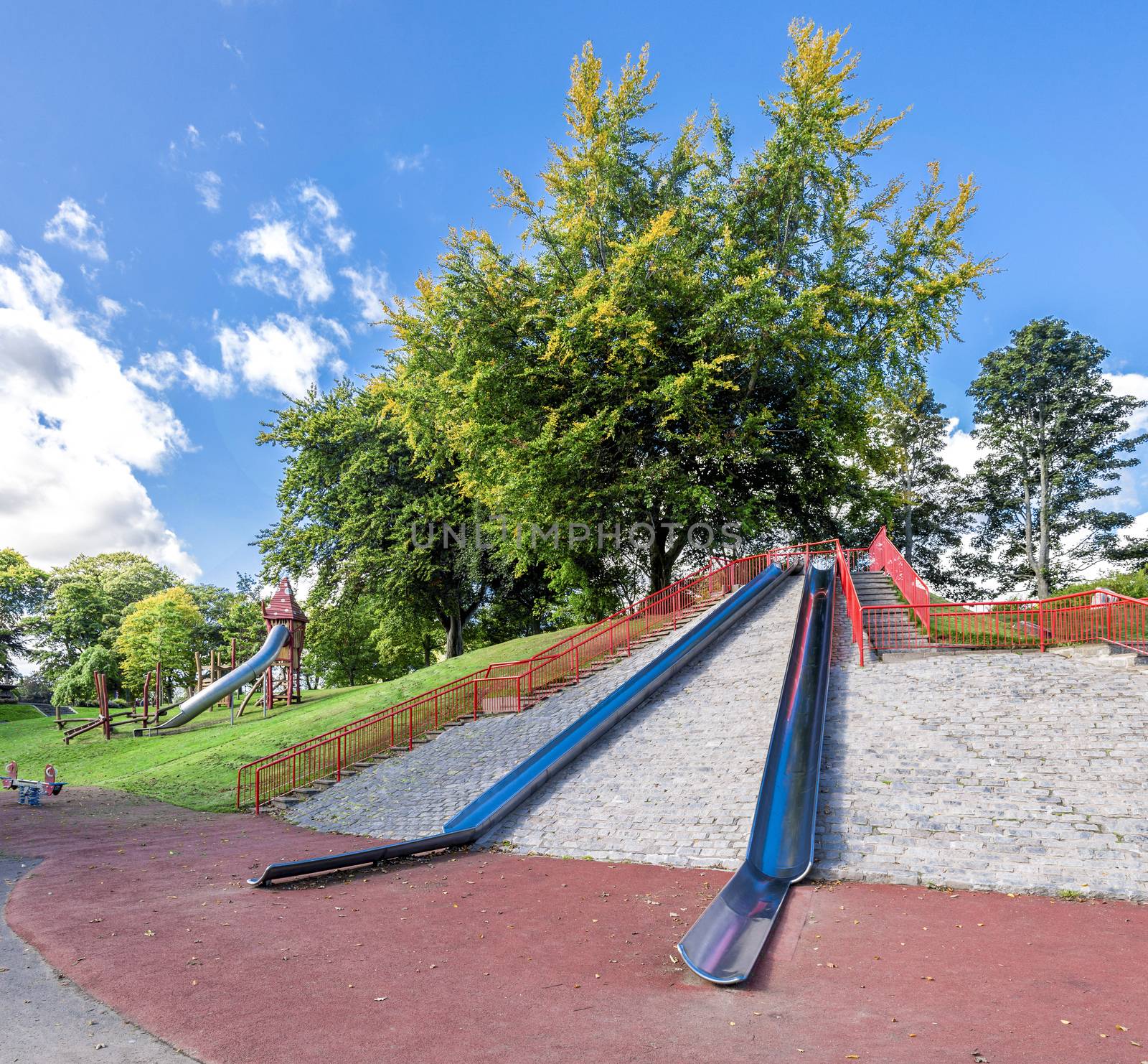 Large metal slides on top of a small hill at the entrance to Duthie Park, Aberdeen, Scotland