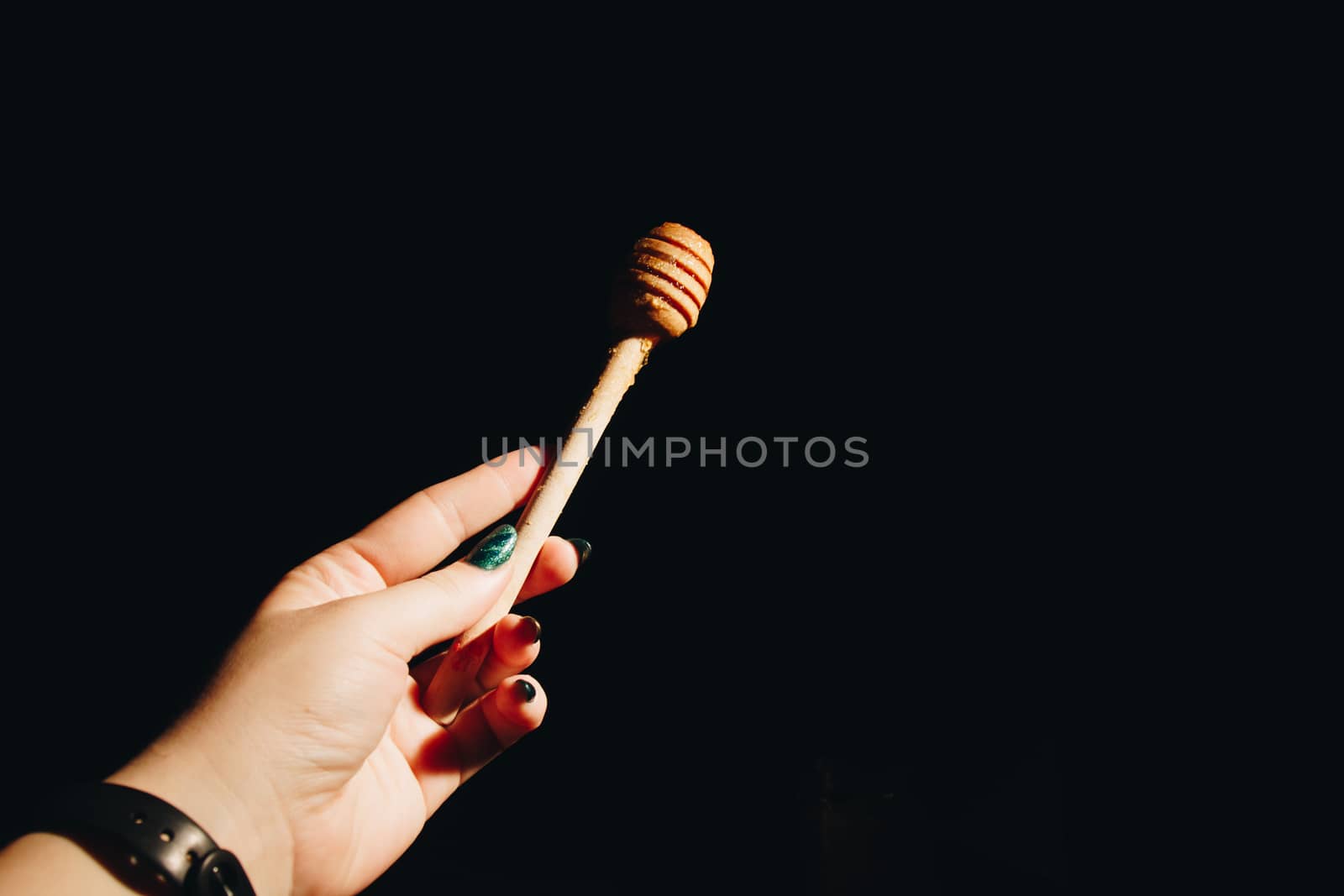 jar of honey with bagels on wooden table close up with honey dipper by yulaphotographer