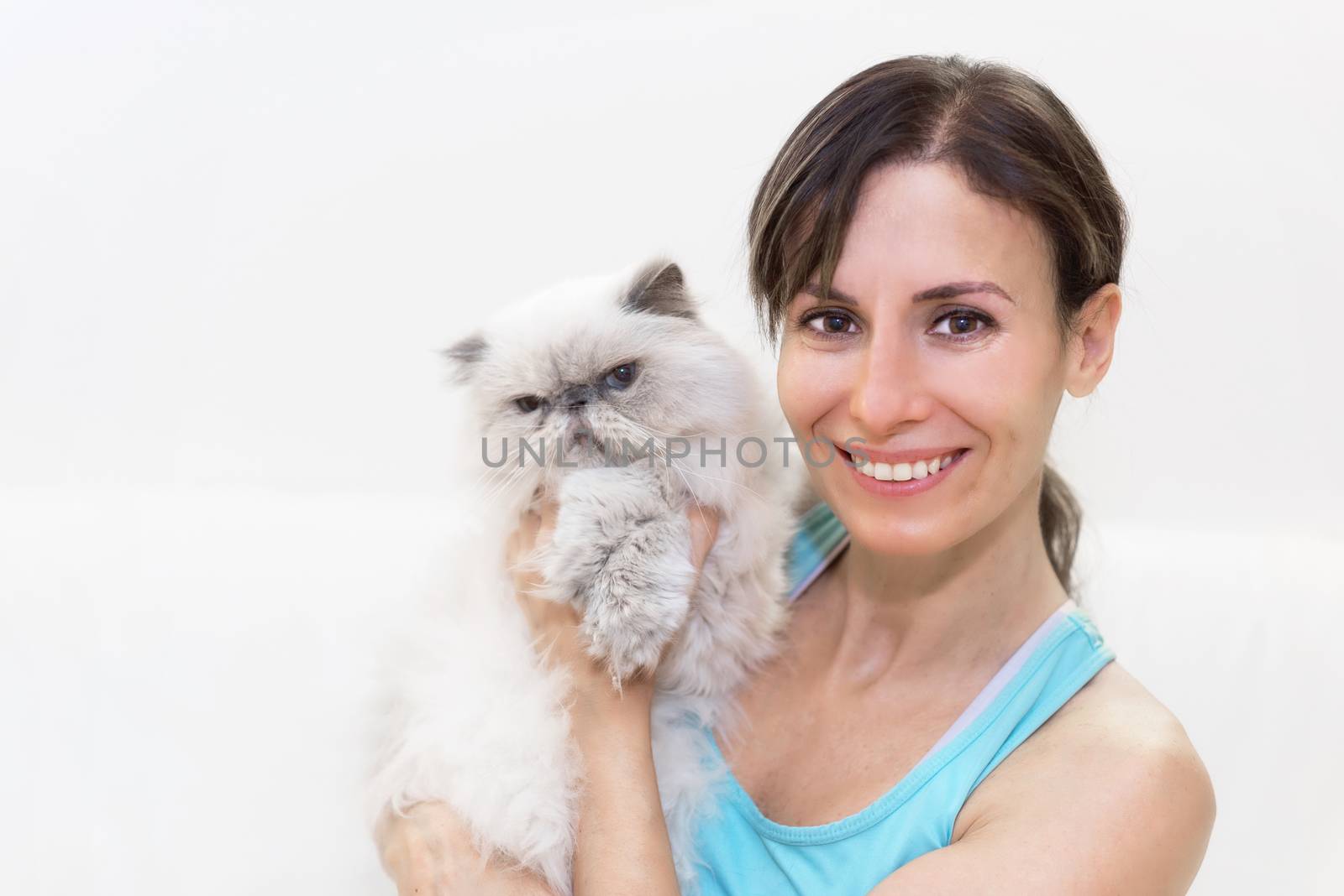 Young woman holding a persian cat