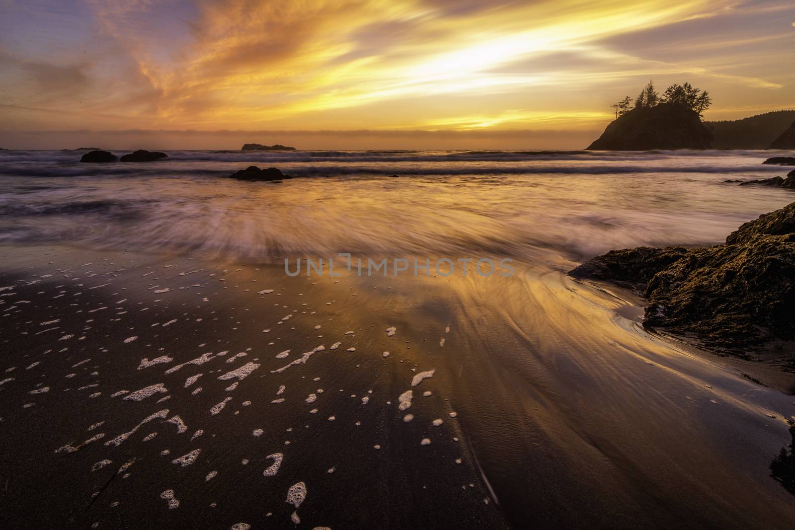 Sunset at a rocky beach with vivid warm colors and beautiful skies.