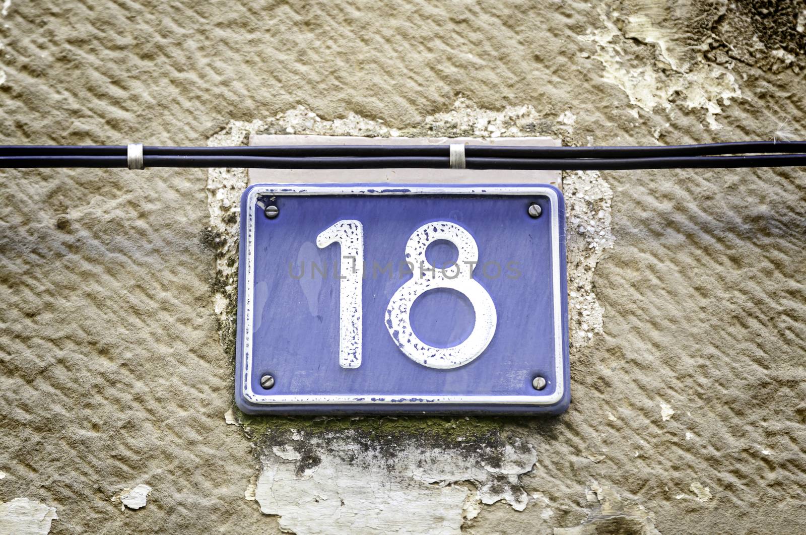 Number eighteen, detail of a number on a wall in the city, and figures signal