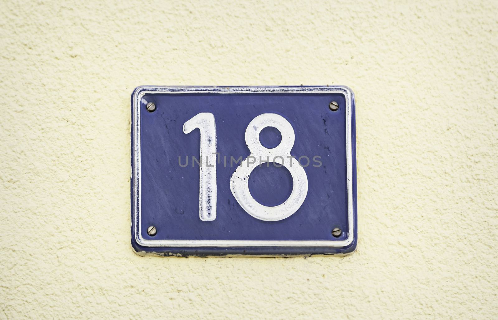 Plate with number eighteen, detail of an old metal plate with infromacion and numbers