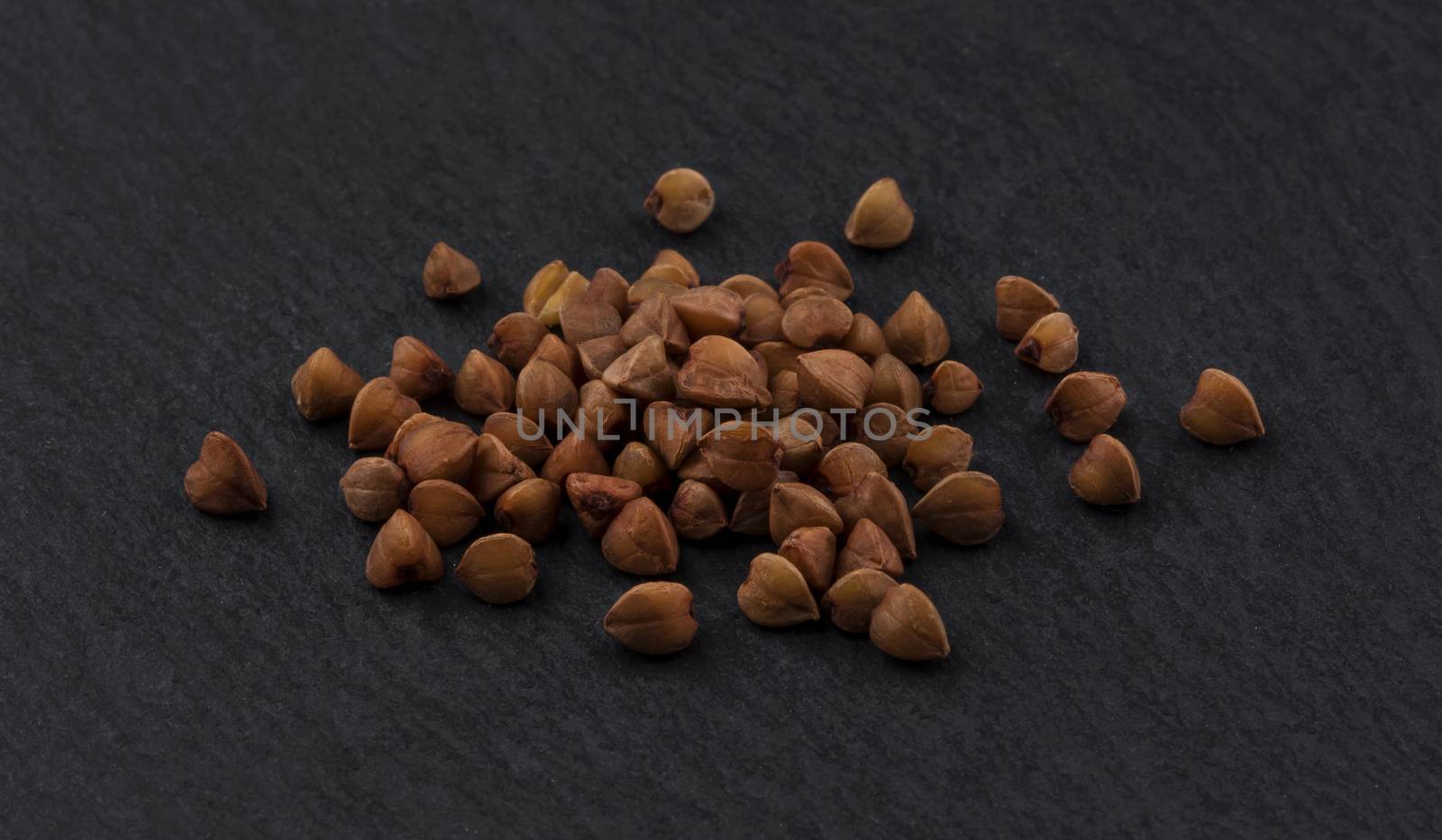 Buckwheat grains on black background by xamtiw