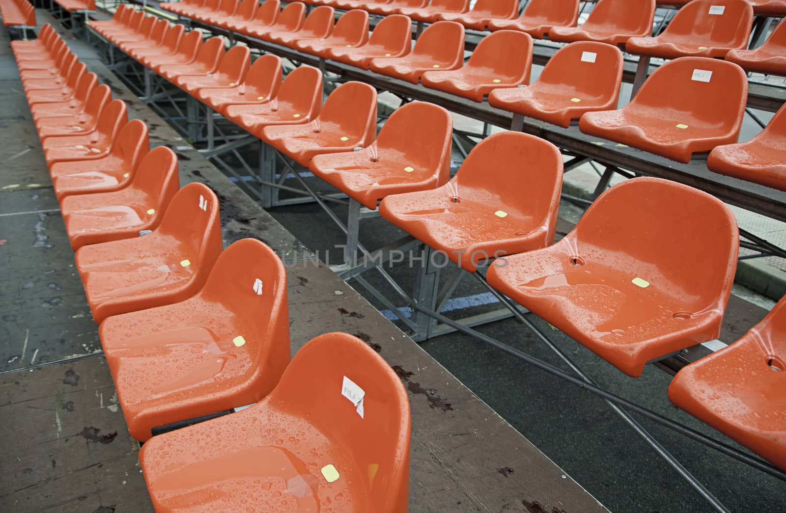 Wet red tiered rows, detail of seats in a bonnet soccer, sport, spectator