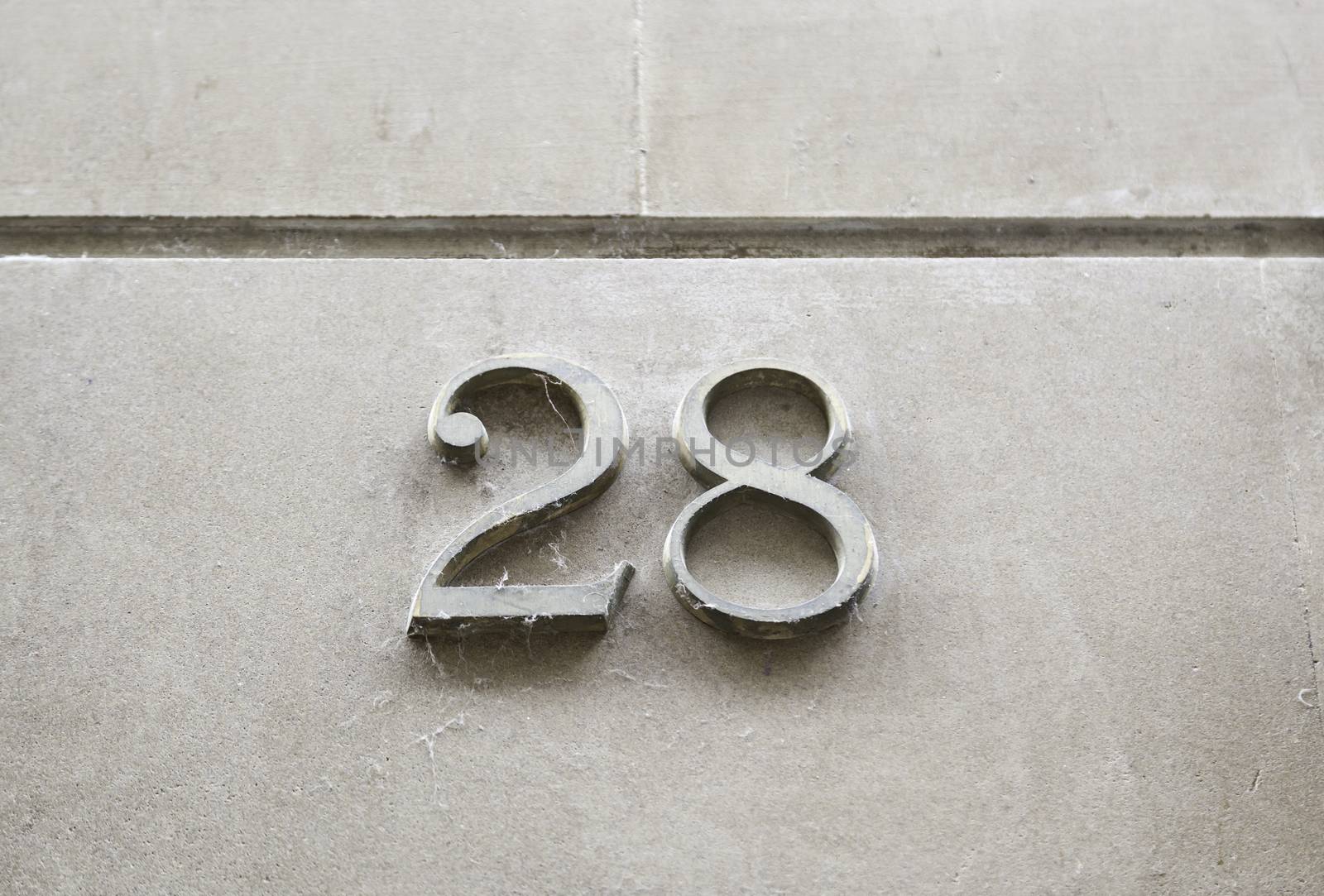 Number twenty-eight on the wall, detail of a number of information on a street, numbers