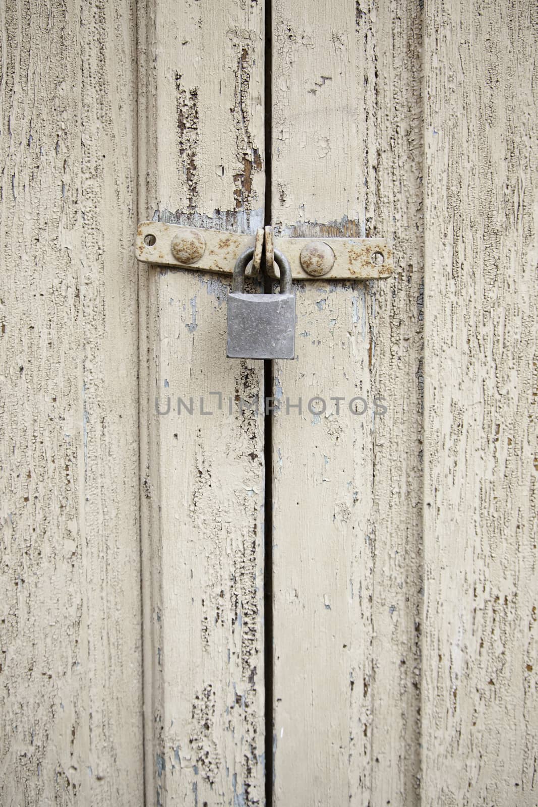 Closed wooden door, detail of an old wooden door locked with a padlock
