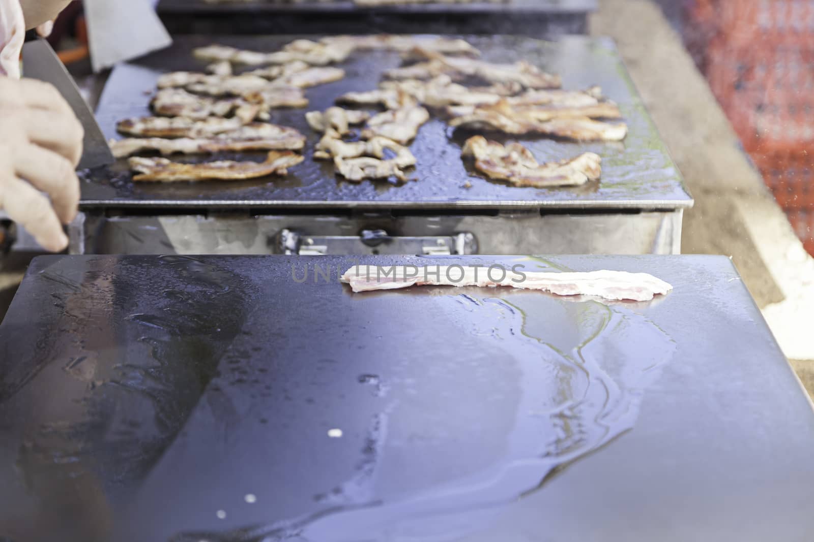 Roasting bacon in grilled pork detail on a griddle to cook, roast