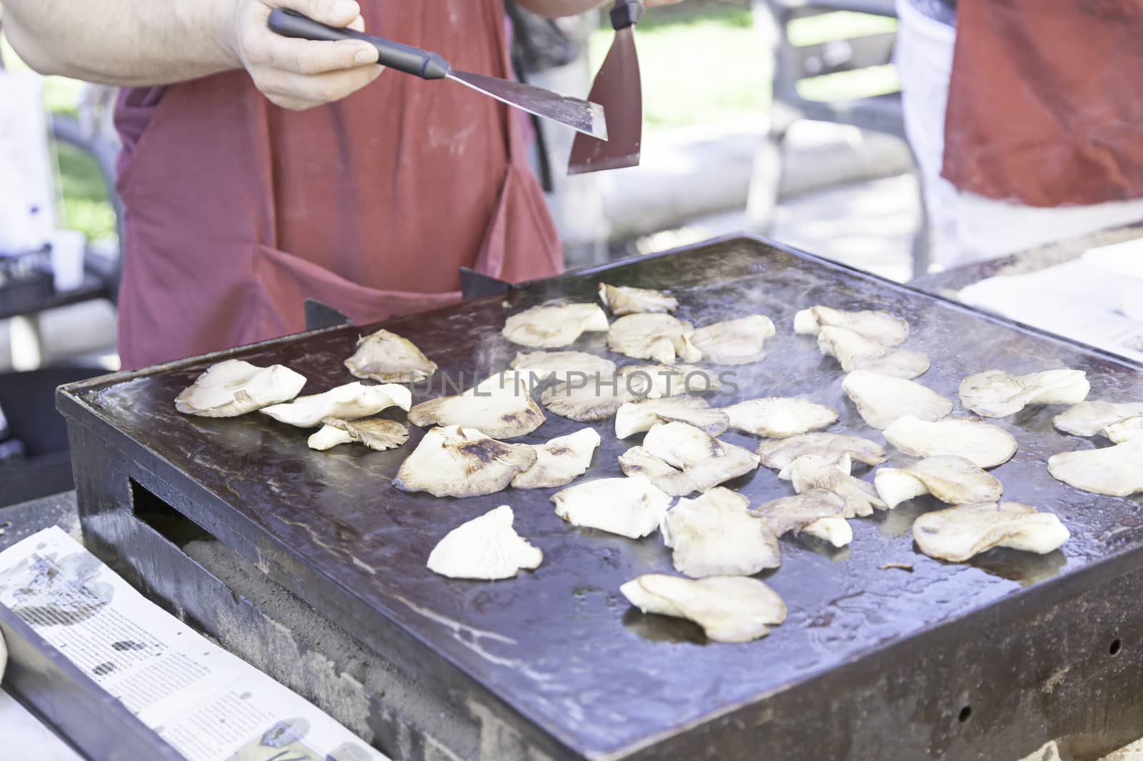 Roasting mushrooms grilled in the street, detail of a public celebration, food healthy lifestyle