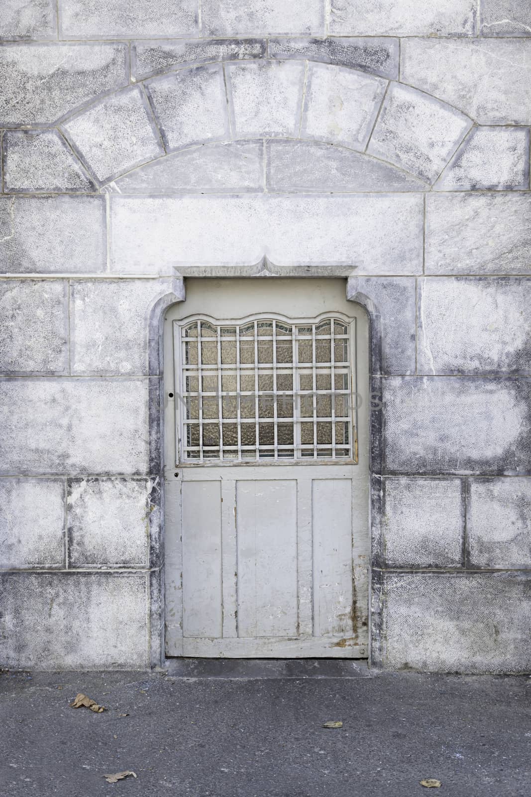 Old metal door in a stone wall, detail of a door in a historic building