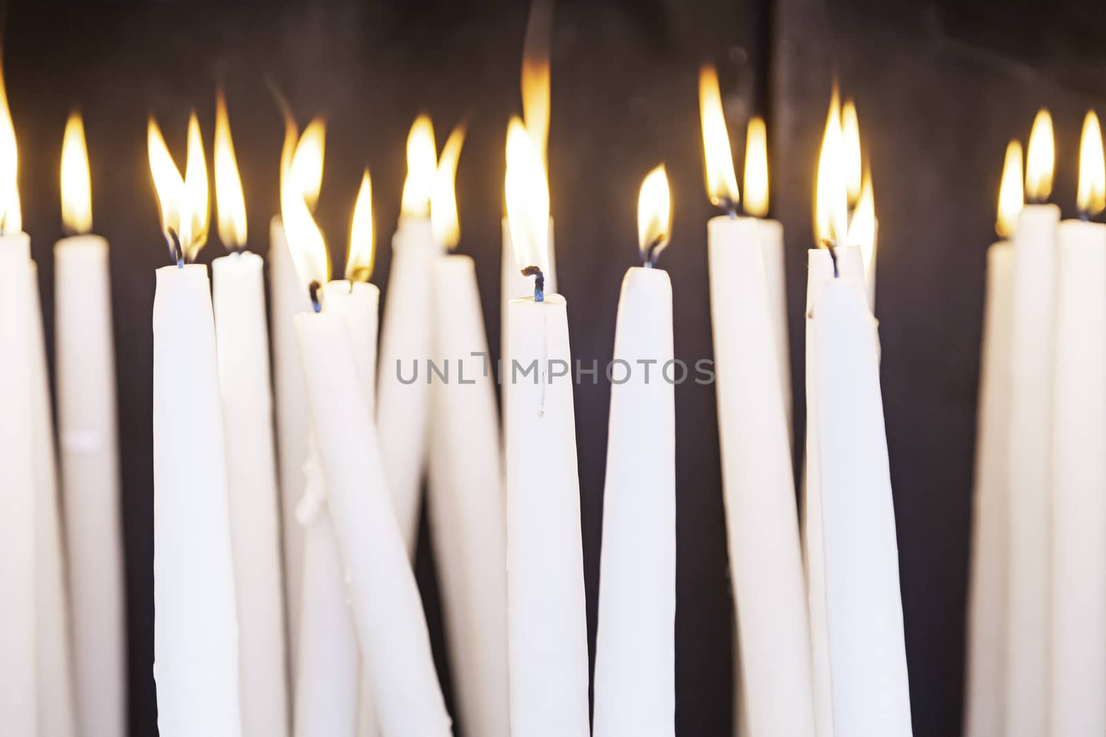 Lighted wax candles, lighted candles detail to pray Christian tradition, fee