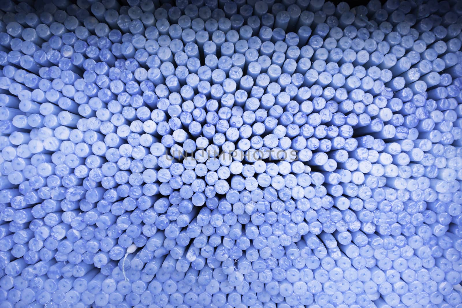 Blue candles piled, detail of a candle in a church, religious belief and faith