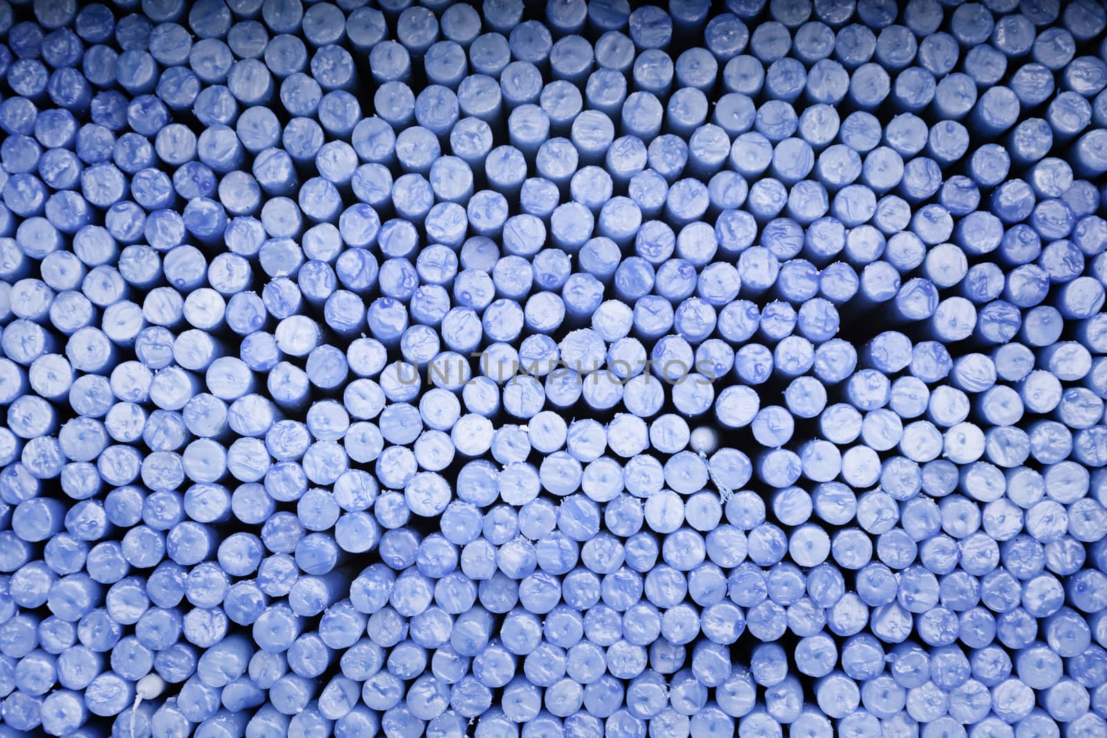 Blue candles piled, detail of a candle in a church, religious belief and faith