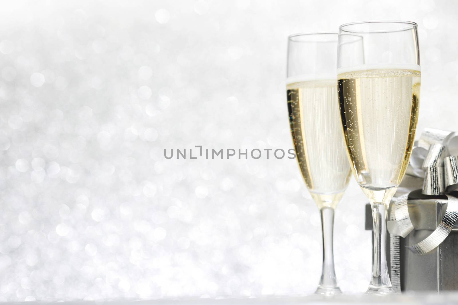 Champagne and present on silver bokeh background