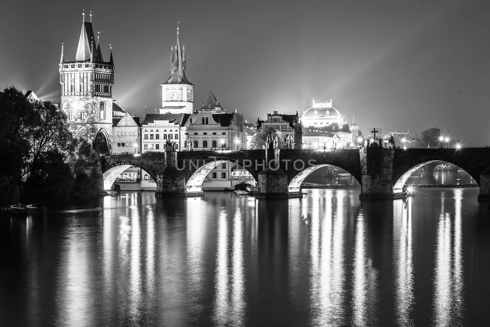 Vltava River and Charles Bridge with Old Town Bridge Tower by night, Prague, Czechia. UNESCO World Heritage Site. Black and white image.