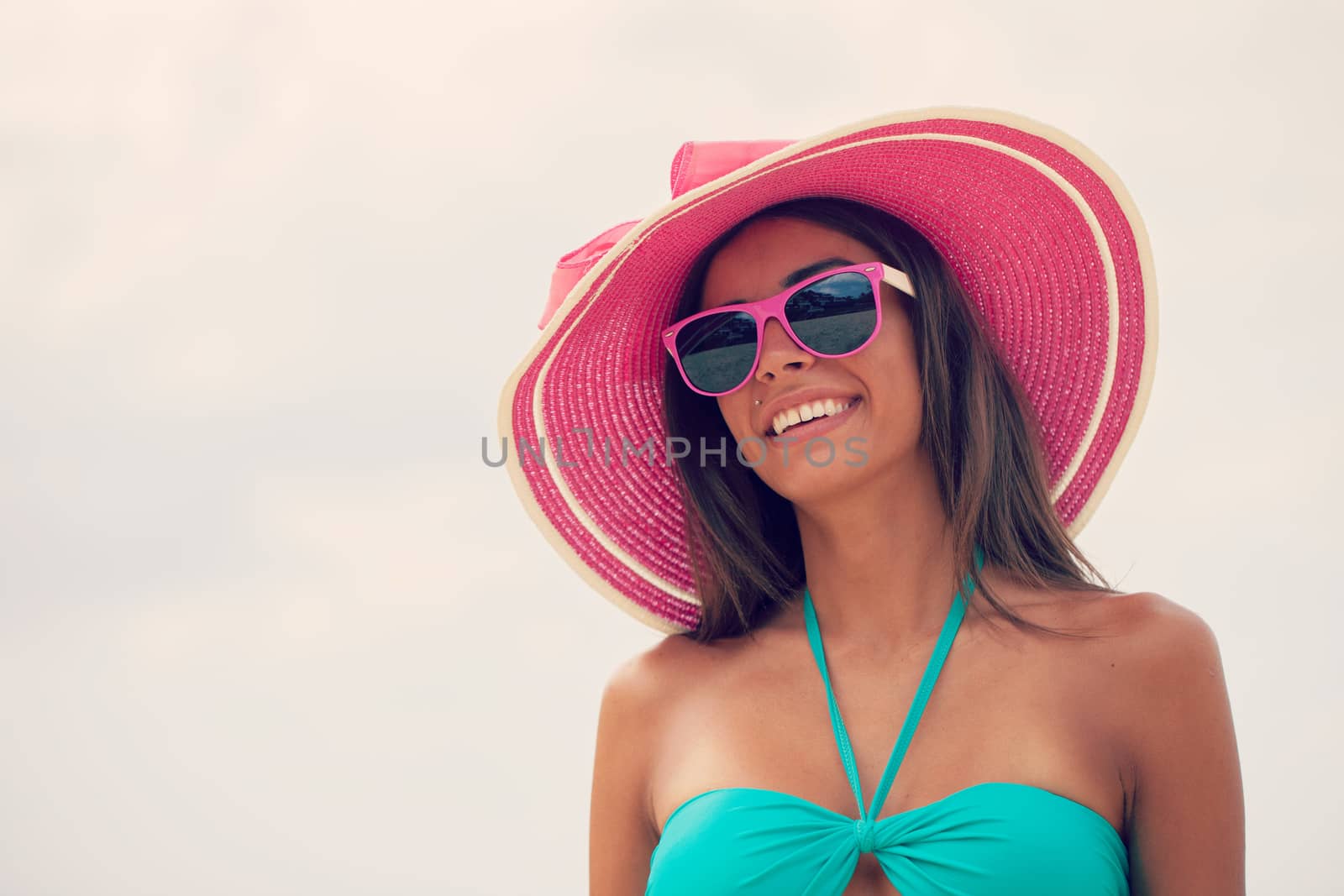 Portrait of a beautiful smiling young woman in bikini and sunhat