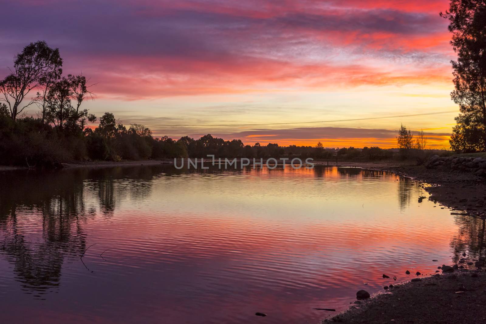 Rural sunrise skies over tranquil lake and countryside at Richmond