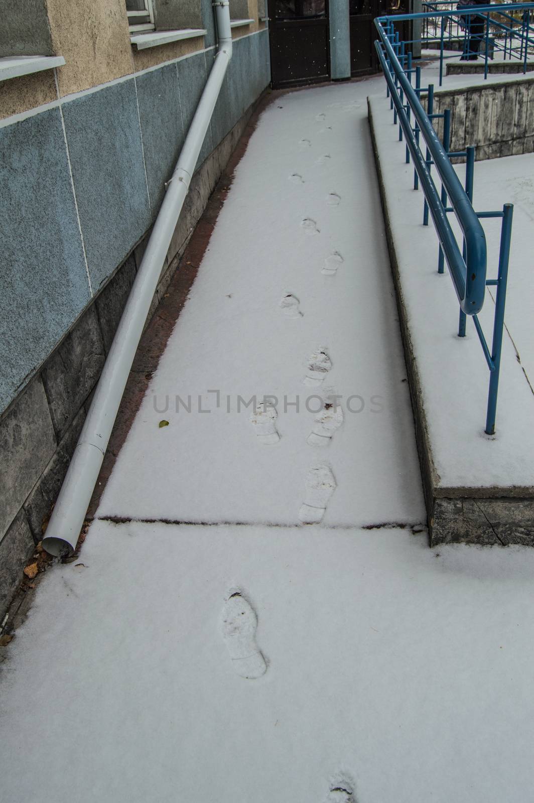 Footprints in the snow on the ramp installed for the movement of people with disabilities at any time of the year.