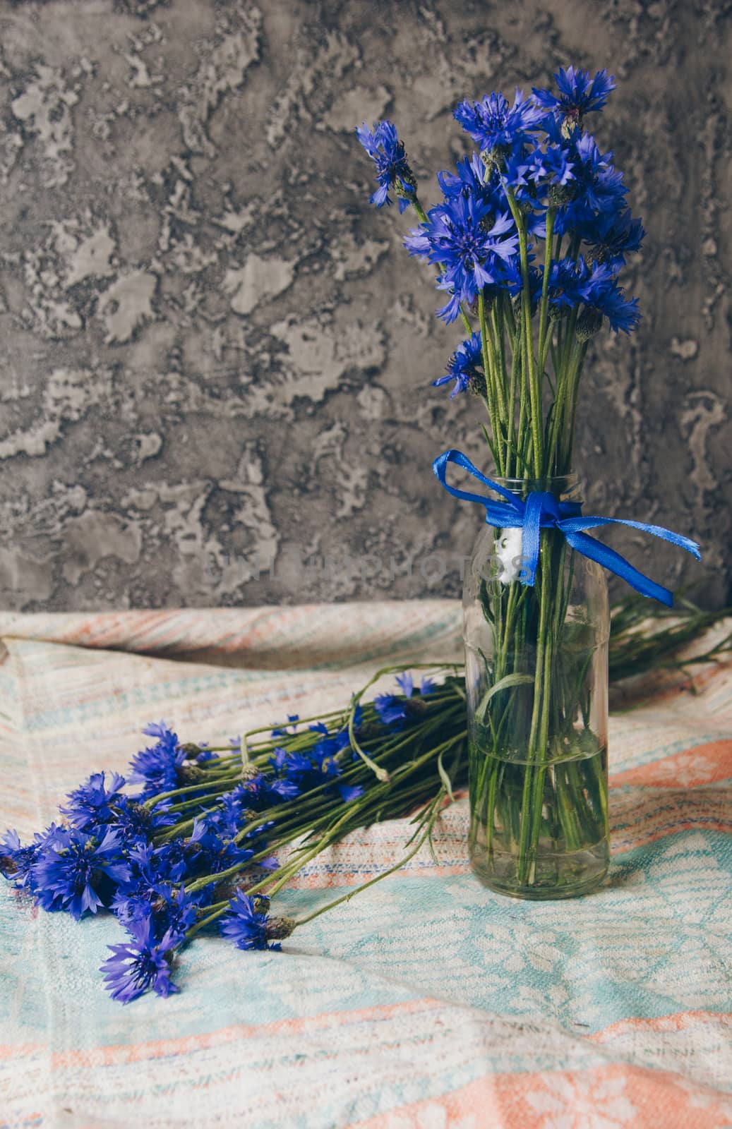 Seasonal summer flowers blue cornflowers and fruits strawberries on a napkin close-up conceptual background by yulaphotographer