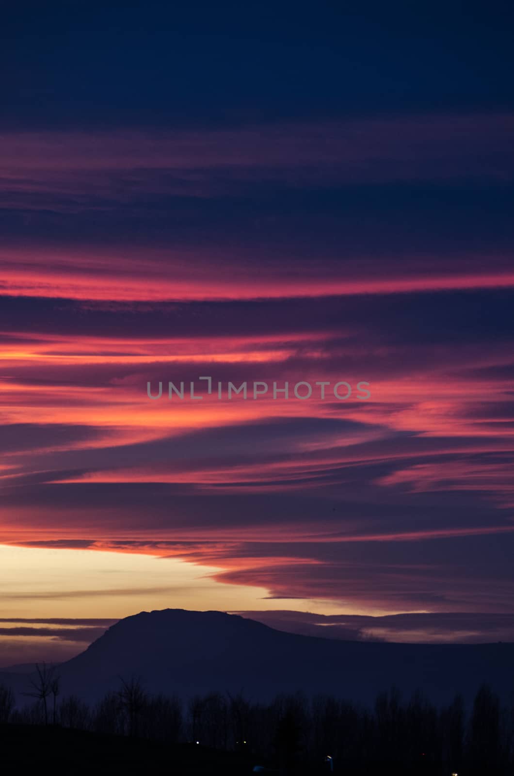 Fluffy orange and purple clouds over the mountain by mikelju