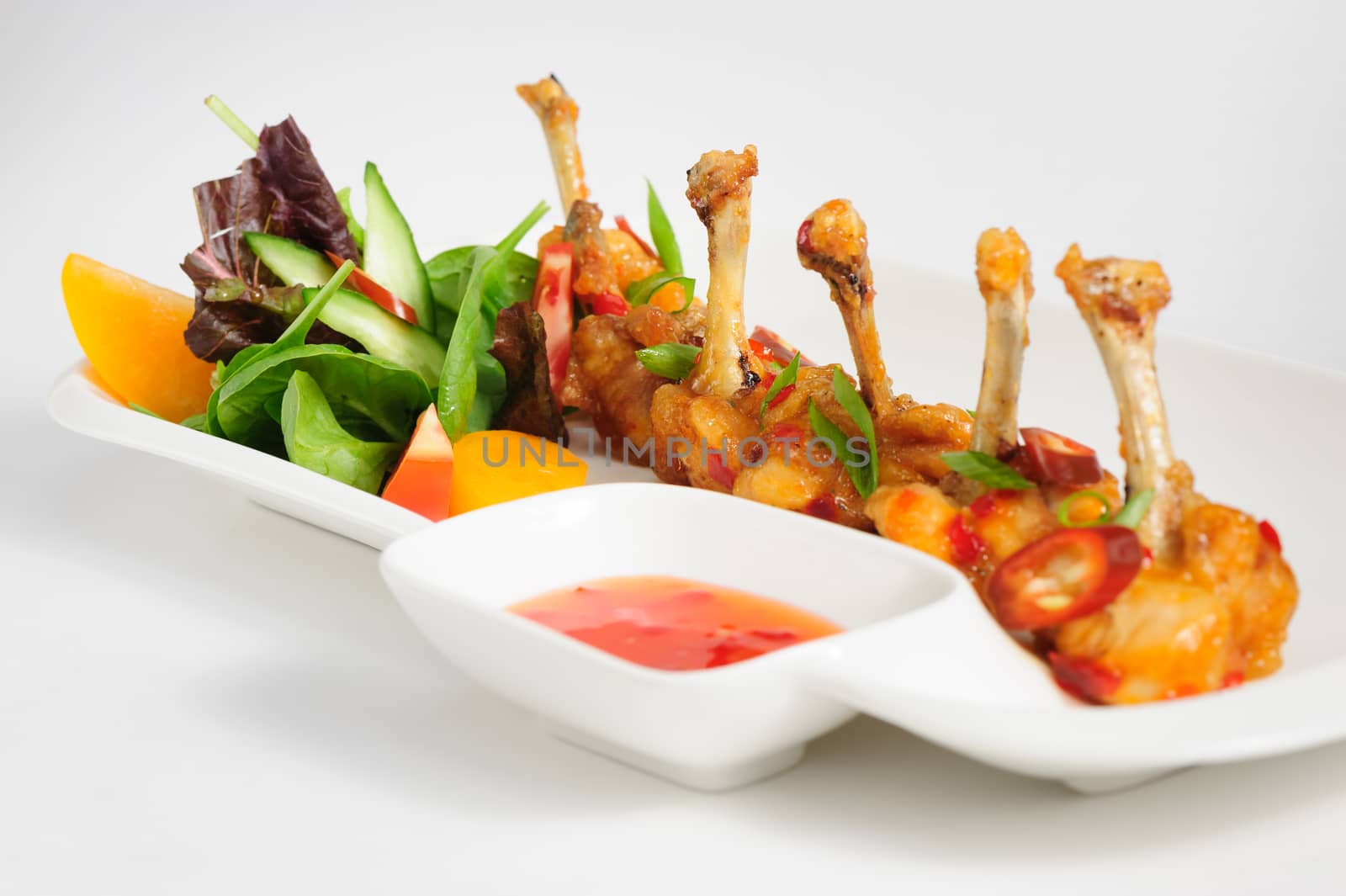 fried chilli chicken wings with vegetable salad and hot sauce