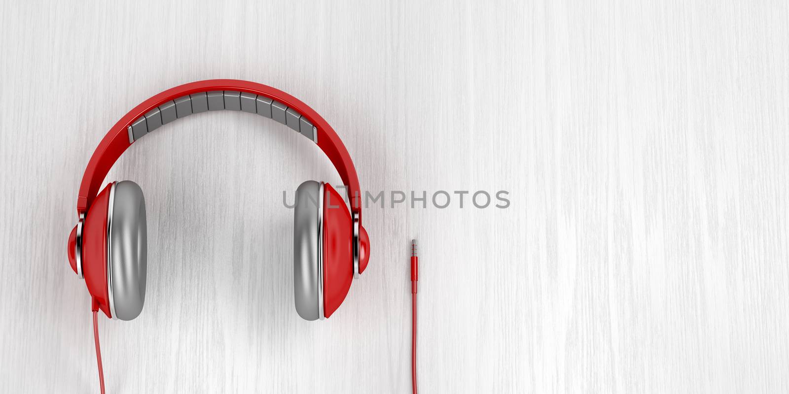 Red over-ear headphones with 3.5mm headphone connector on wood background