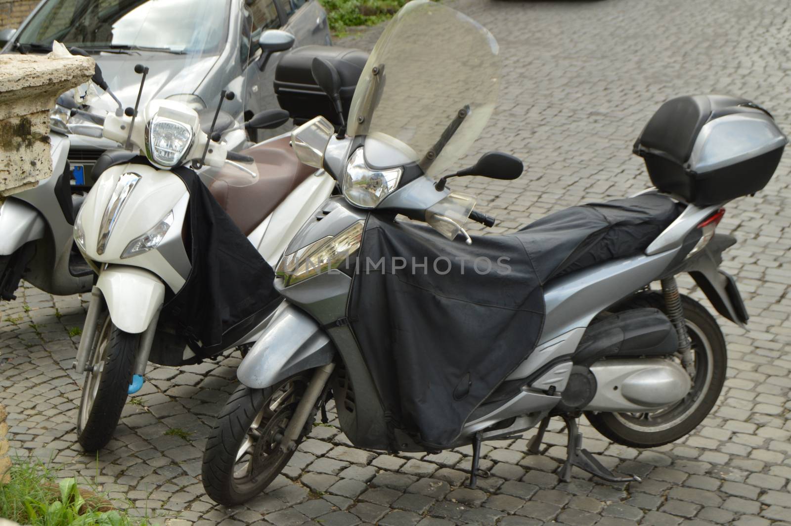 Two black motorcycles are parked on the street in Rome, Italy.