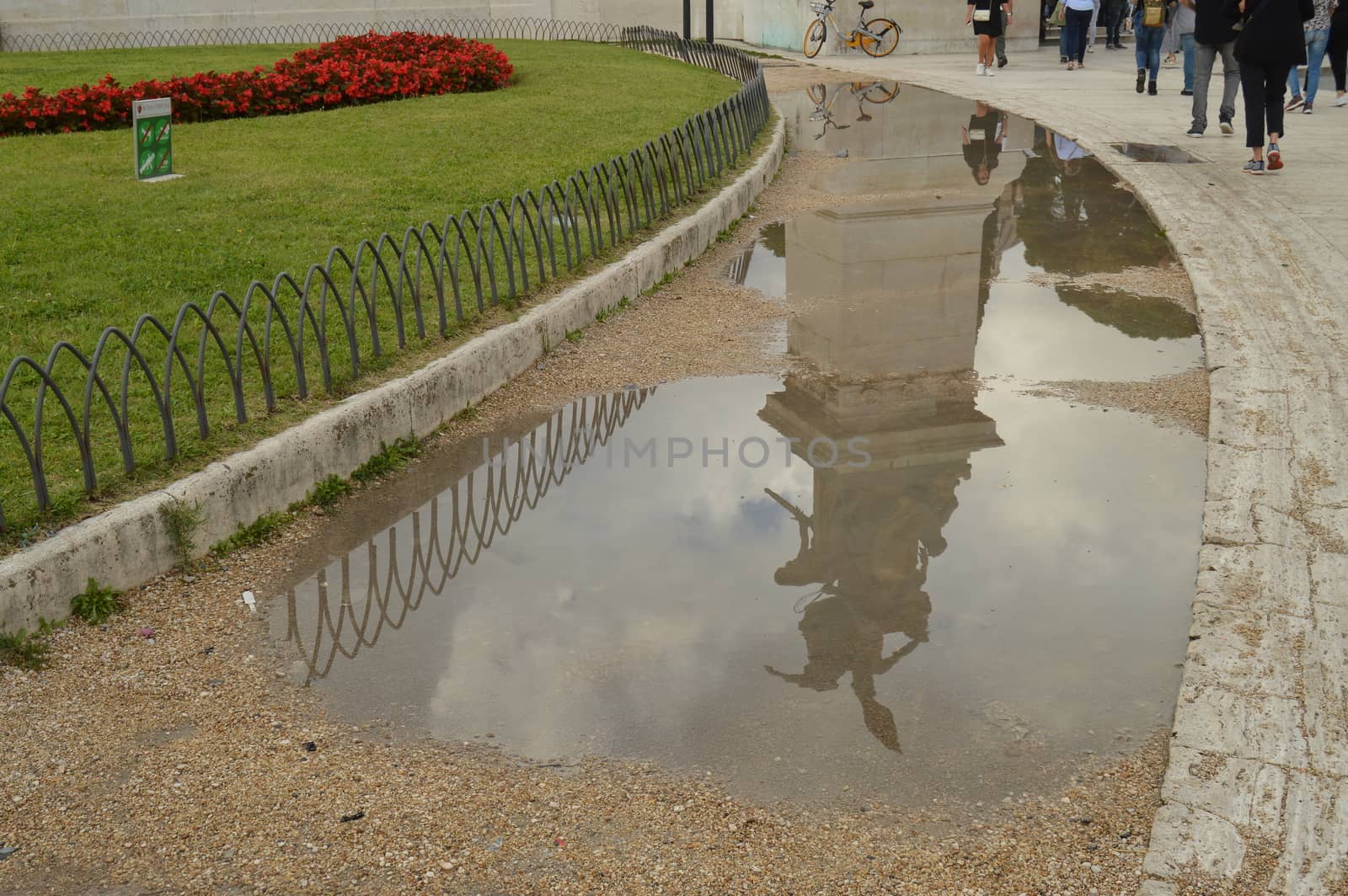 A reflection in a puddle after the rain Statue in the Vittoriano monument of Vittorio Emanuele II in Rome, Italy on October 07, 2018 by claire_lucia