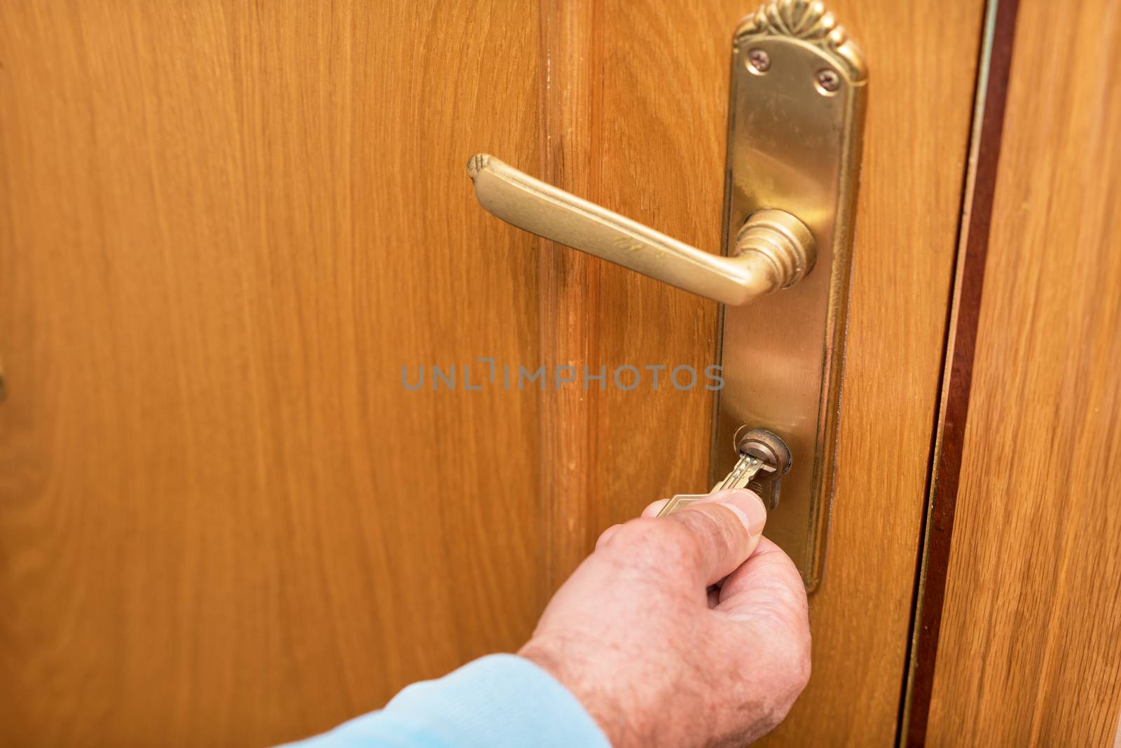 Senior man Locking up door with key in hand